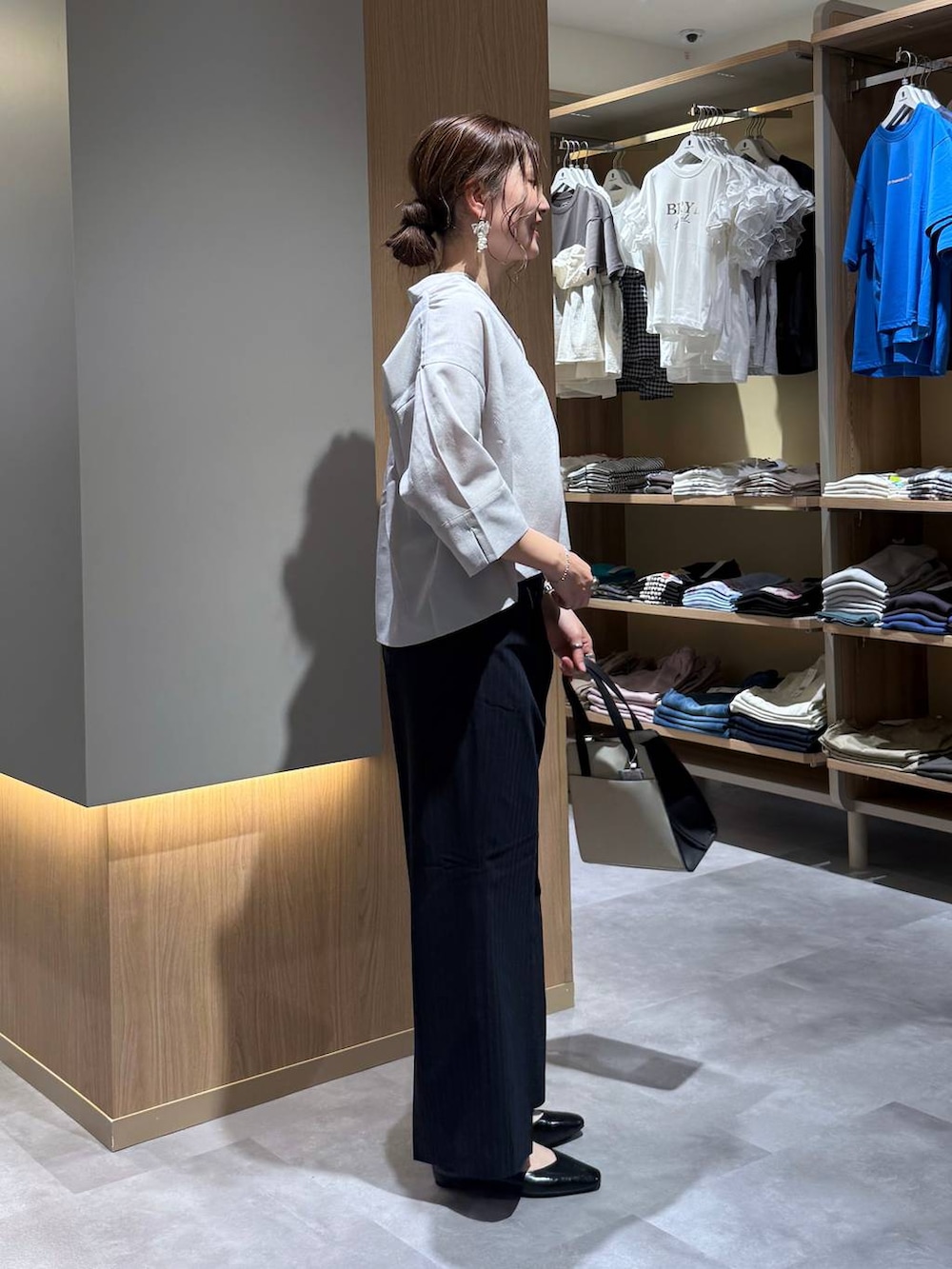 ブラック系のパンプス、ホワイト系のショルダーバッグ、ブルー系のその他パンツを着用したレディースの夏コーディネートの3枚目の写真