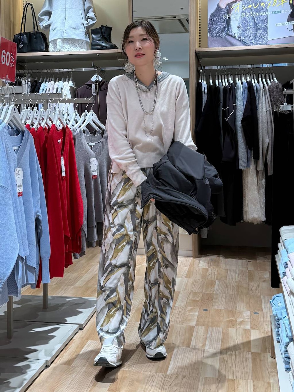 ブラック系のブルゾン、ホワイト系のニット/セーター、ベージュ系のその他パンツを着用したレディースの冬コーディネートの2枚目の写真