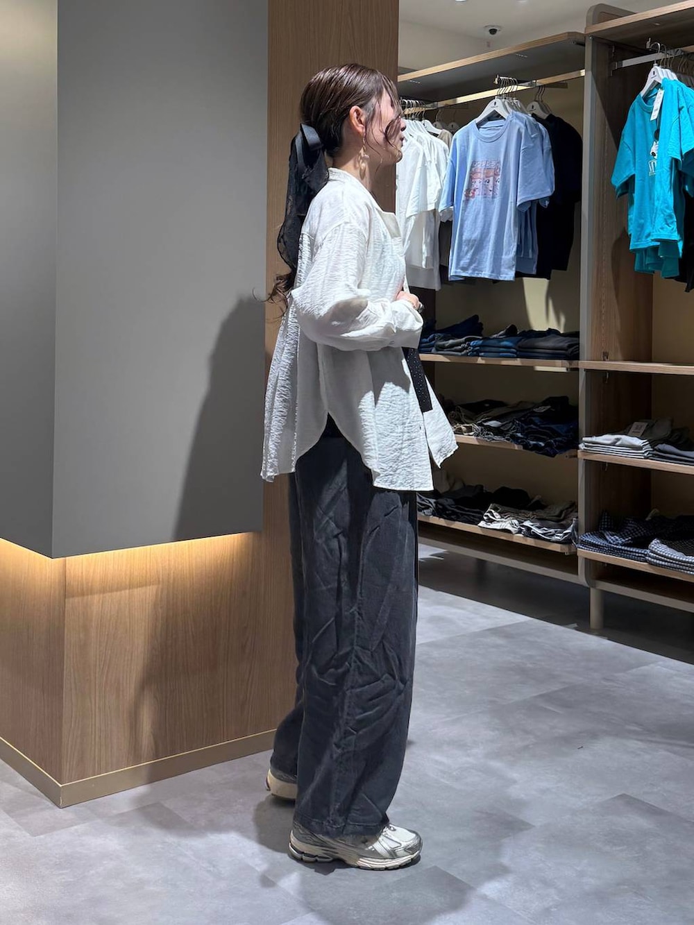 ベージュ系のパーカー、ブラック系のデニムパンツ、ホワイト系のシャツ/ブラウスを着用したレディースの春コーディネートの3枚目の写真