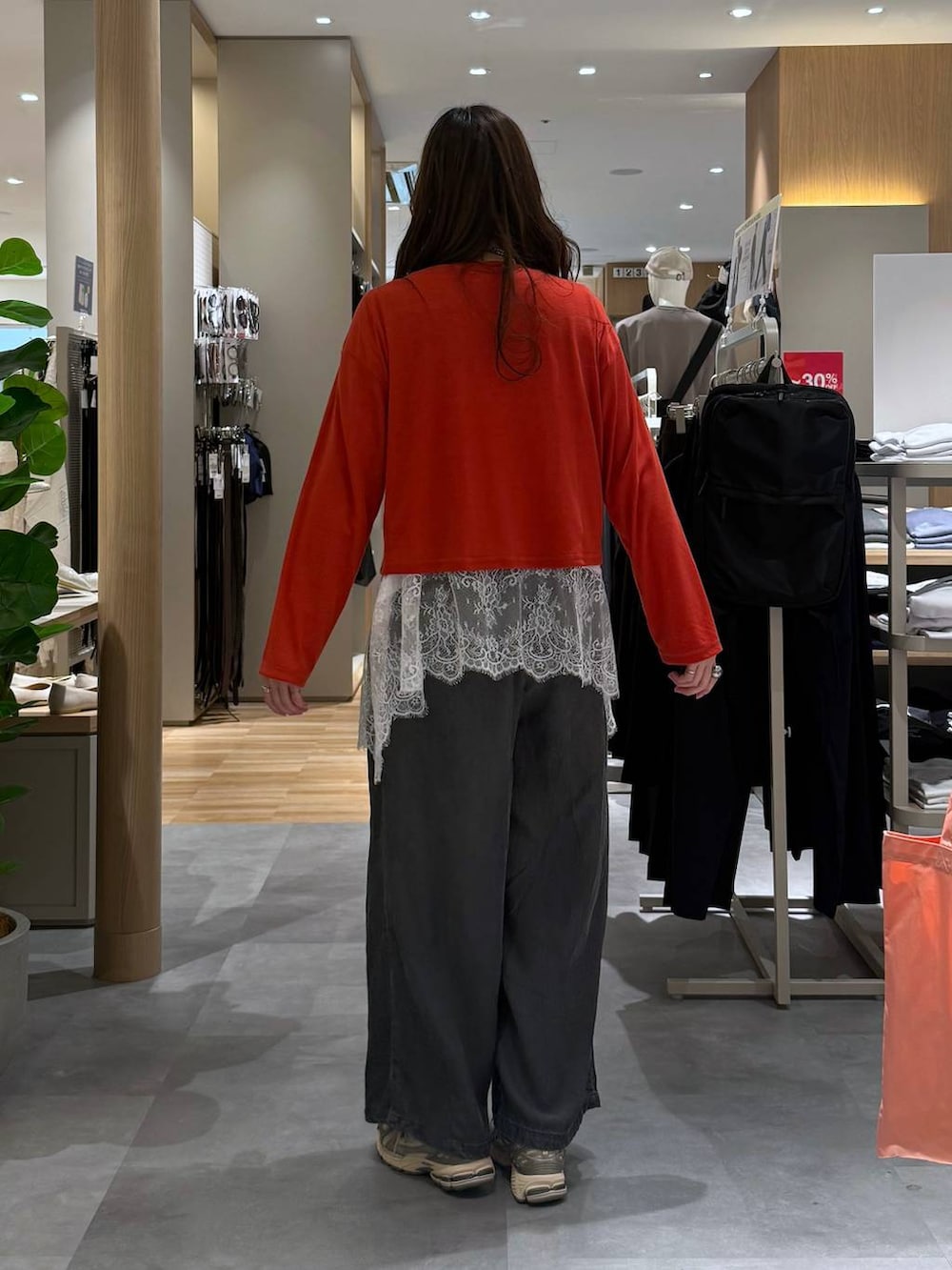 ホワイト系のTシャツ/カットソー、オレンジ系のカーディガン/ボレロ、ブラック系のデニムパンツを着用したレディースの春コーディネートの5枚目の写真