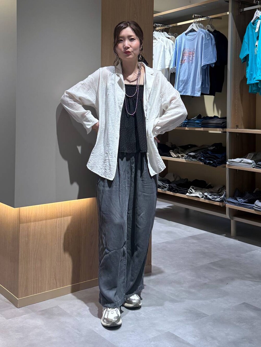 ベージュ系のパーカー、ブラック系のデニムパンツ、ホワイト系のシャツ/ブラウスを着用したレディースの春コーディネートの2枚目の写真