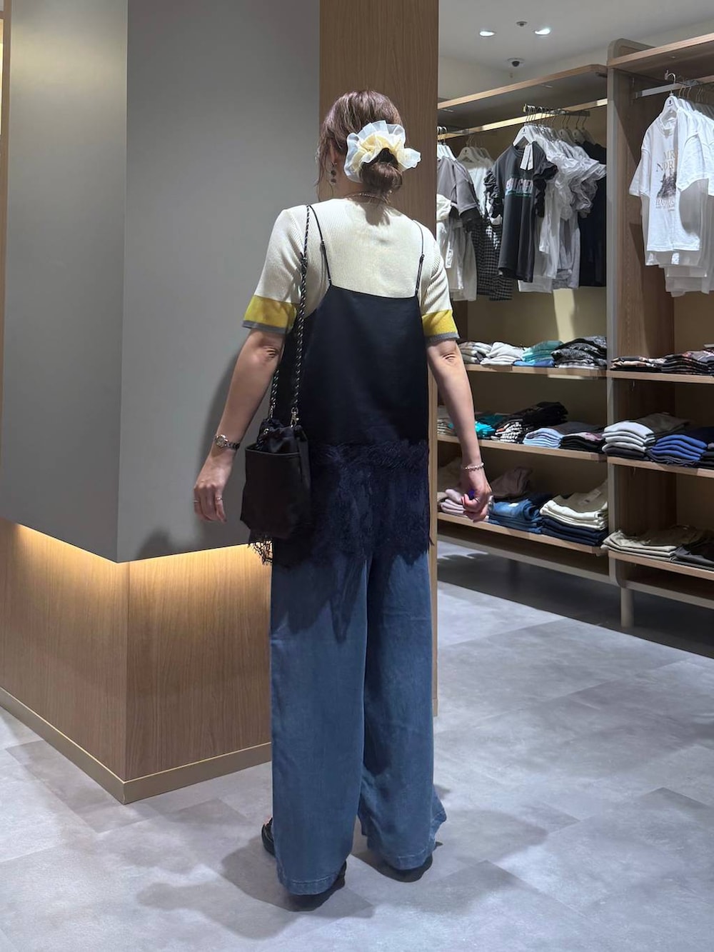 ブルー系のデニムパンツ、グレー系のボディバッグ/ウエストポーチ、イエロー系のニット/セーターを着用したレディースの夏コーディネートの5枚目の写真