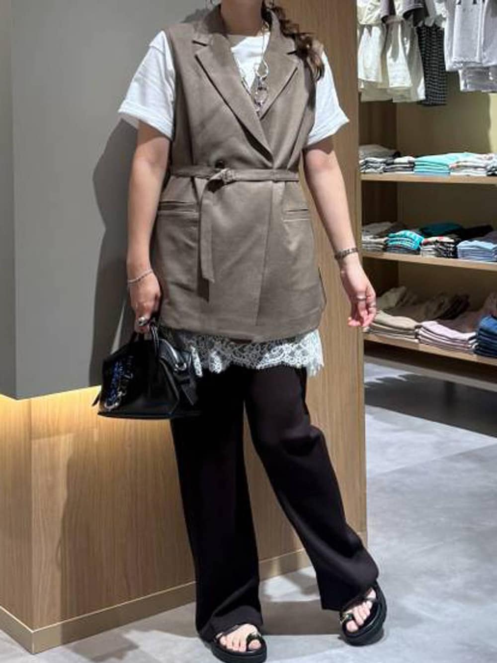 ブラウン系のベスト、ホワイト系のTシャツ/カットソー、ブラック系のボストンバッグを着用したレディースの夏コーディネートの5枚目の写真