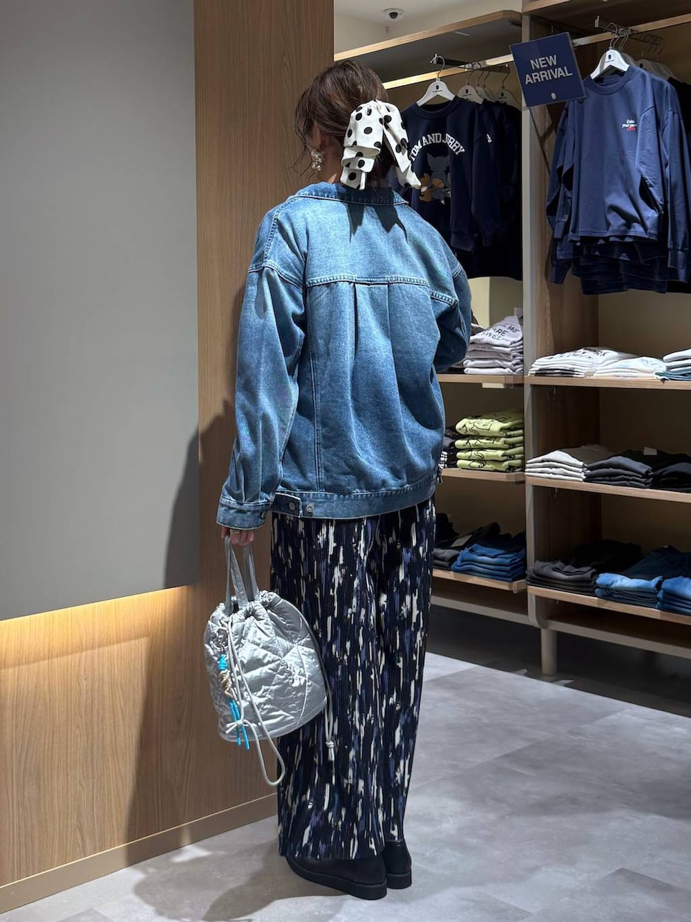 ブラック系のローファー、シルバー系のハンドバッグ、ブルー系のデニムジャケットを着用したレディースの春コーディネートの4枚目の写真