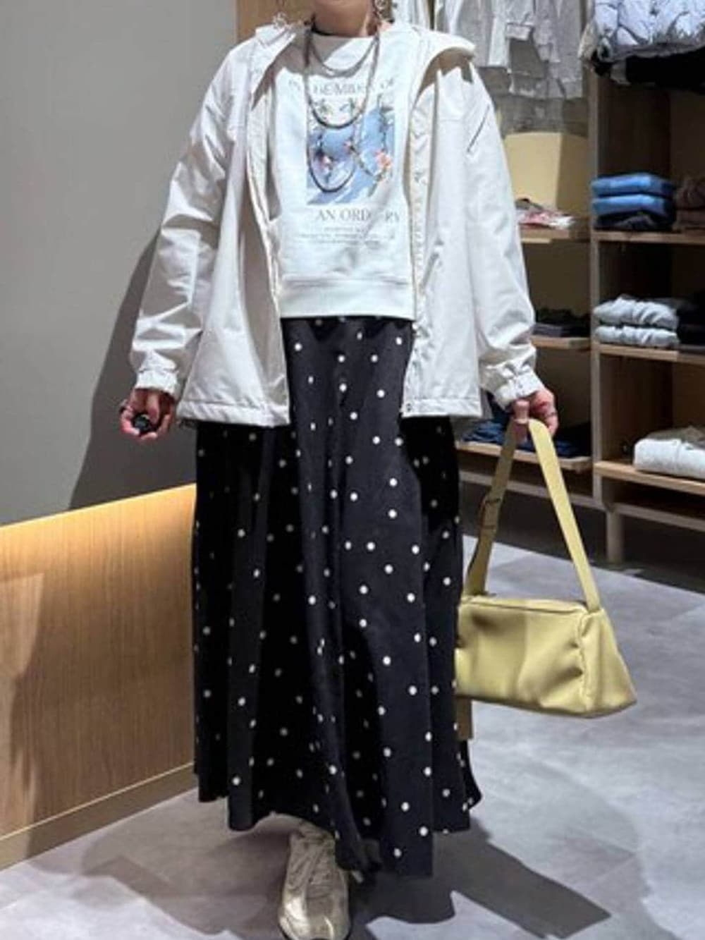 グレー系のニット/セーター、ホワイト系のスウェット、ベージュ系のマウンテンパーカーを着用したレディースの春コーディネートの5枚目の写真