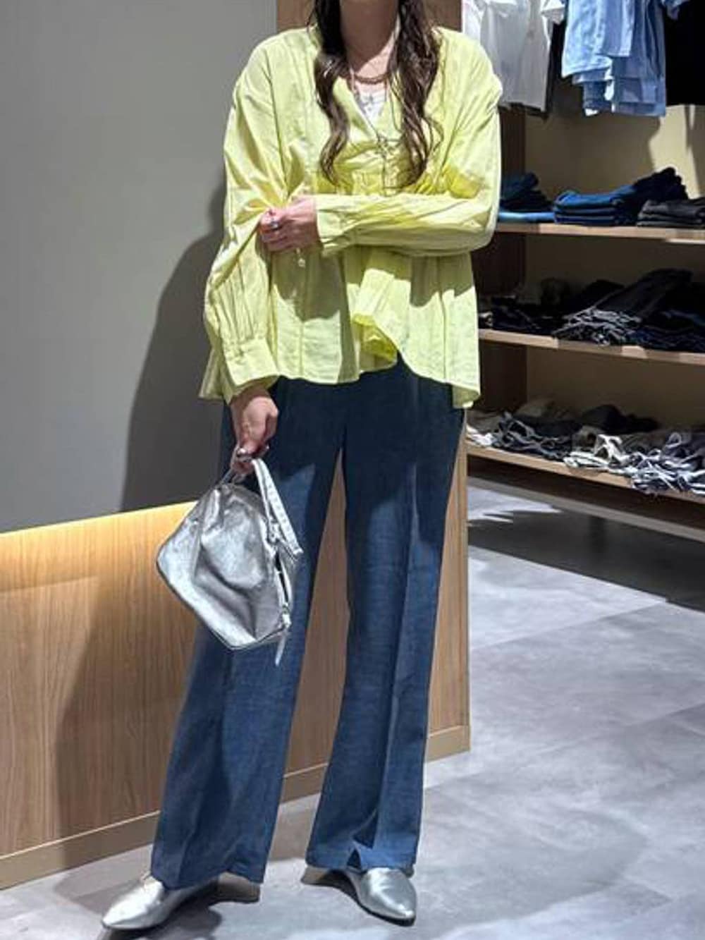 シルバー系のショルダーバッグ、シルバー系のパンプス、ホワイト系のタンクトップを着用したレディースの秋コーディネートの5枚目の写真