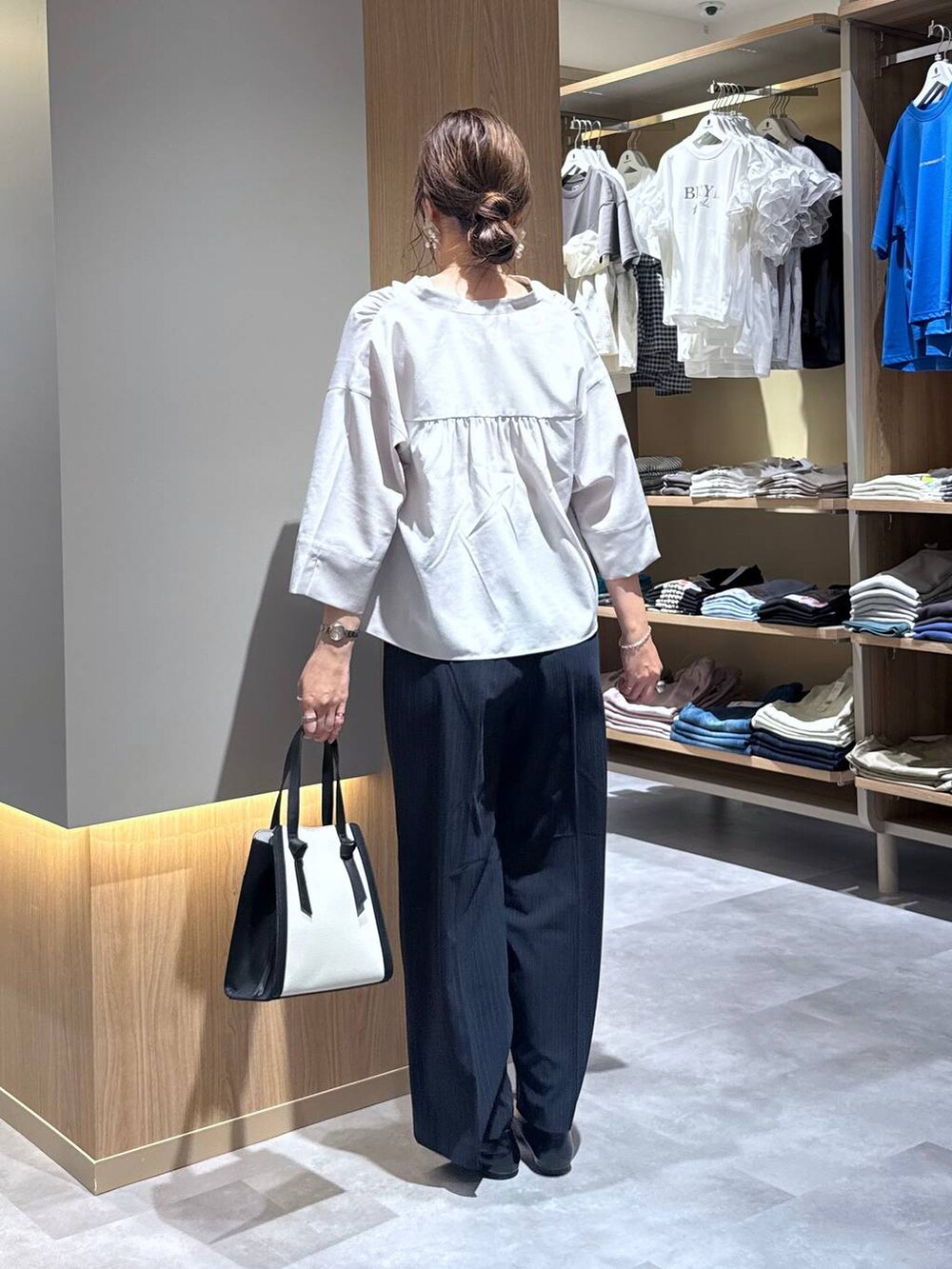 ブラック系のパンプス、ホワイト系のショルダーバッグ、ブルー系のその他パンツを着用したレディースの夏コーディネートの4枚目の写真