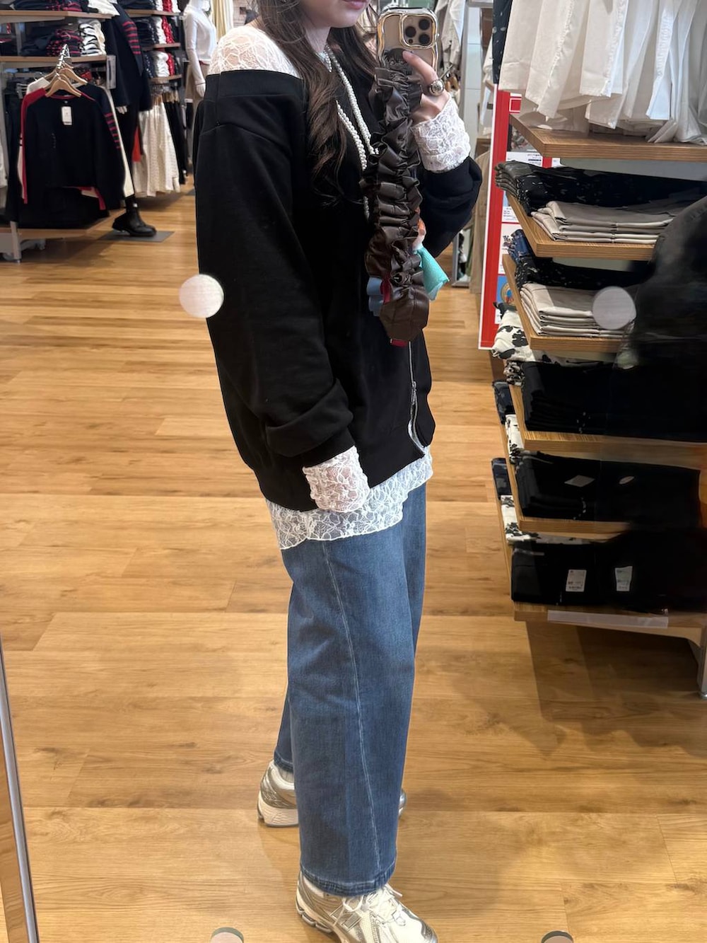 グレー系のベスト、ブルー系のデニムパンツ、ブラック系のTシャツ/カットソーを着用したレディースの春コーディネートの6枚目の写真