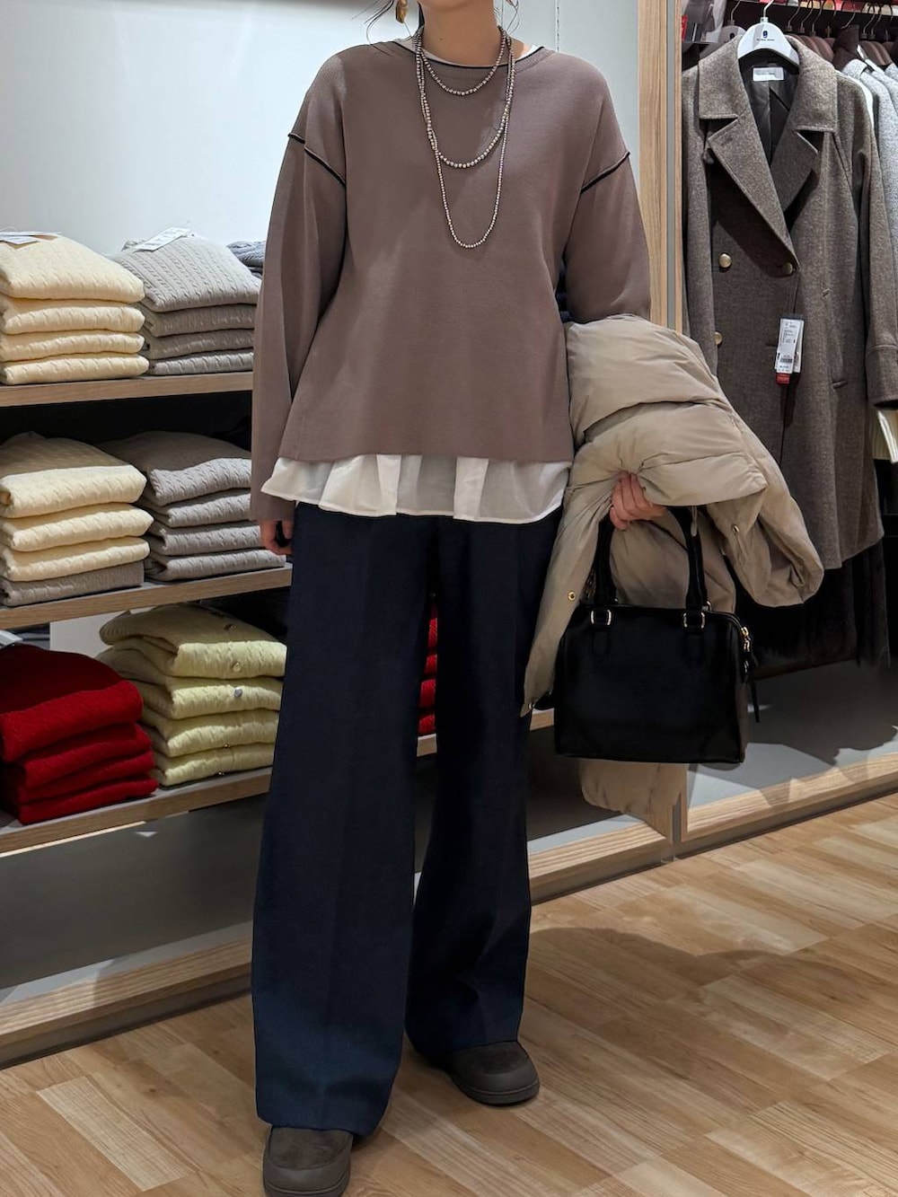 ベージュ系のダウンジャケット/コート、ブルー系のその他パンツ、ホワイト系のTシャツ/カットソーを着用したレディースの春コーディネートの5枚目の写真