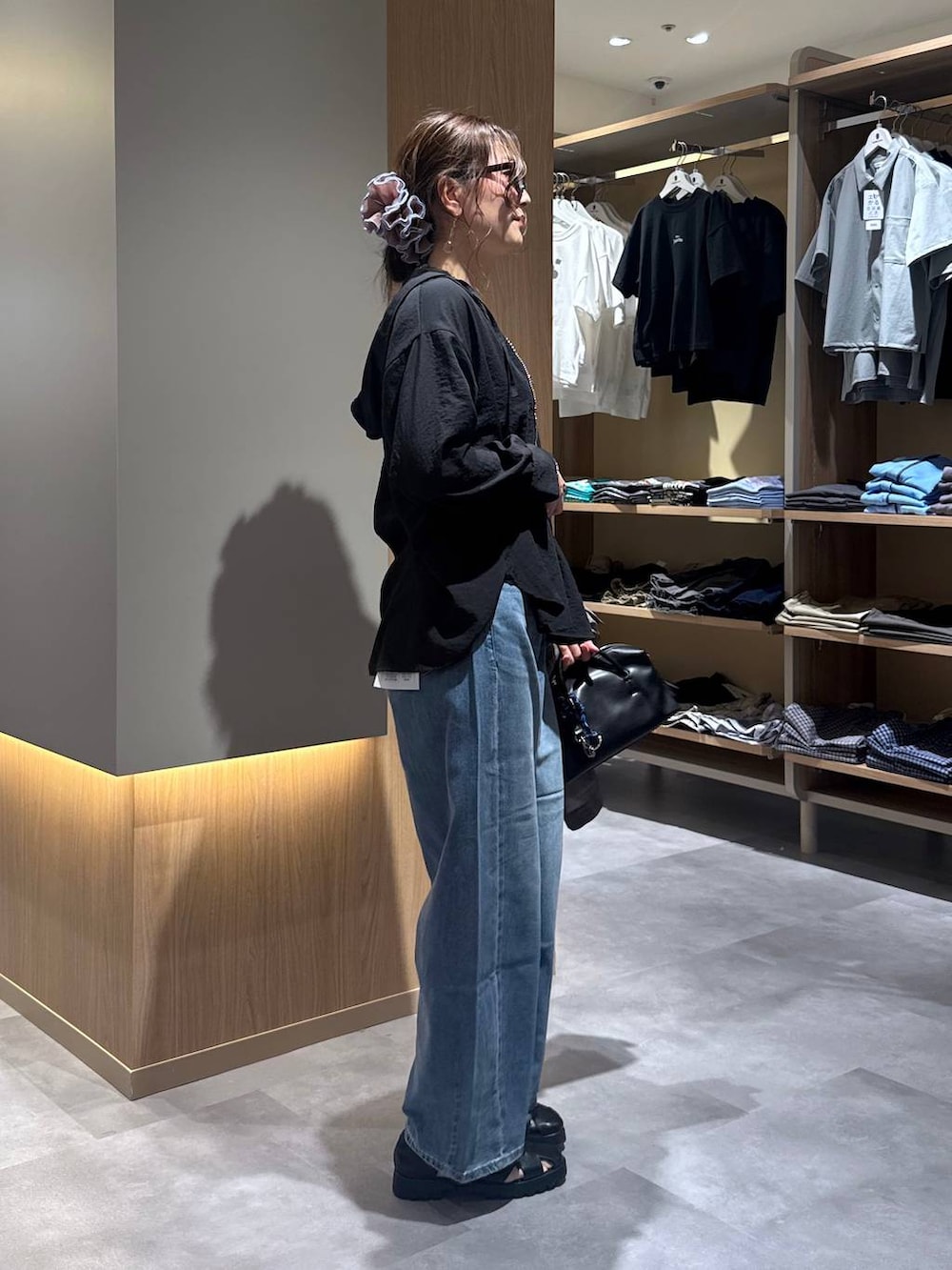 ブルー系のデニムパンツ、グレー系のテーラードジャケット、ホワイト系のタンクトップを着用したレディースの夏コーディネートの3枚目の写真