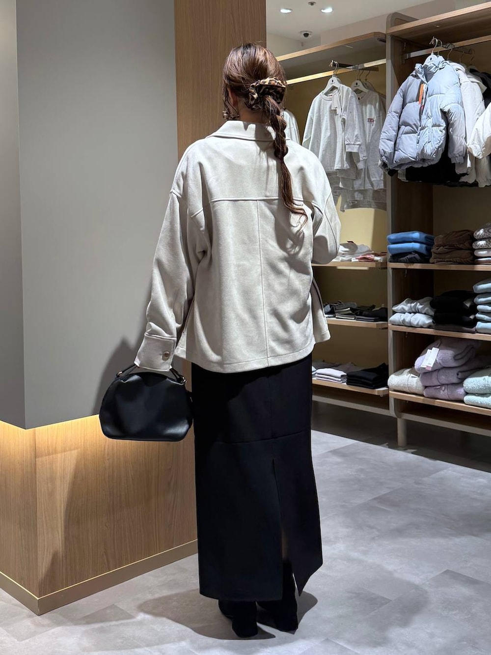 ブラック系のショルダーバッグ、ホワイト系のTシャツ/カットソー、ブラック系のブーツを着用したレディースの冬コーディネートの4枚目の写真