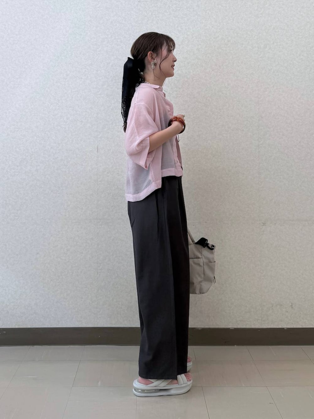 ブラック系のトートバッグ、ブラウン系のその他パンツ、ピンク系のシャツ/ブラウスを着用したレディースの夏コーディネートの3枚目の写真