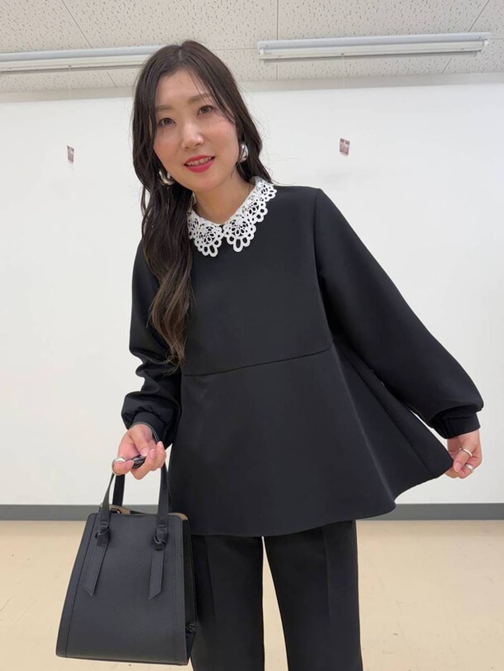 ブラック系のショルダーバッグ、ブラック系のセットアップ、ブラック系のパンプスを着用したレディースの冬コーディネートの3枚目の写真