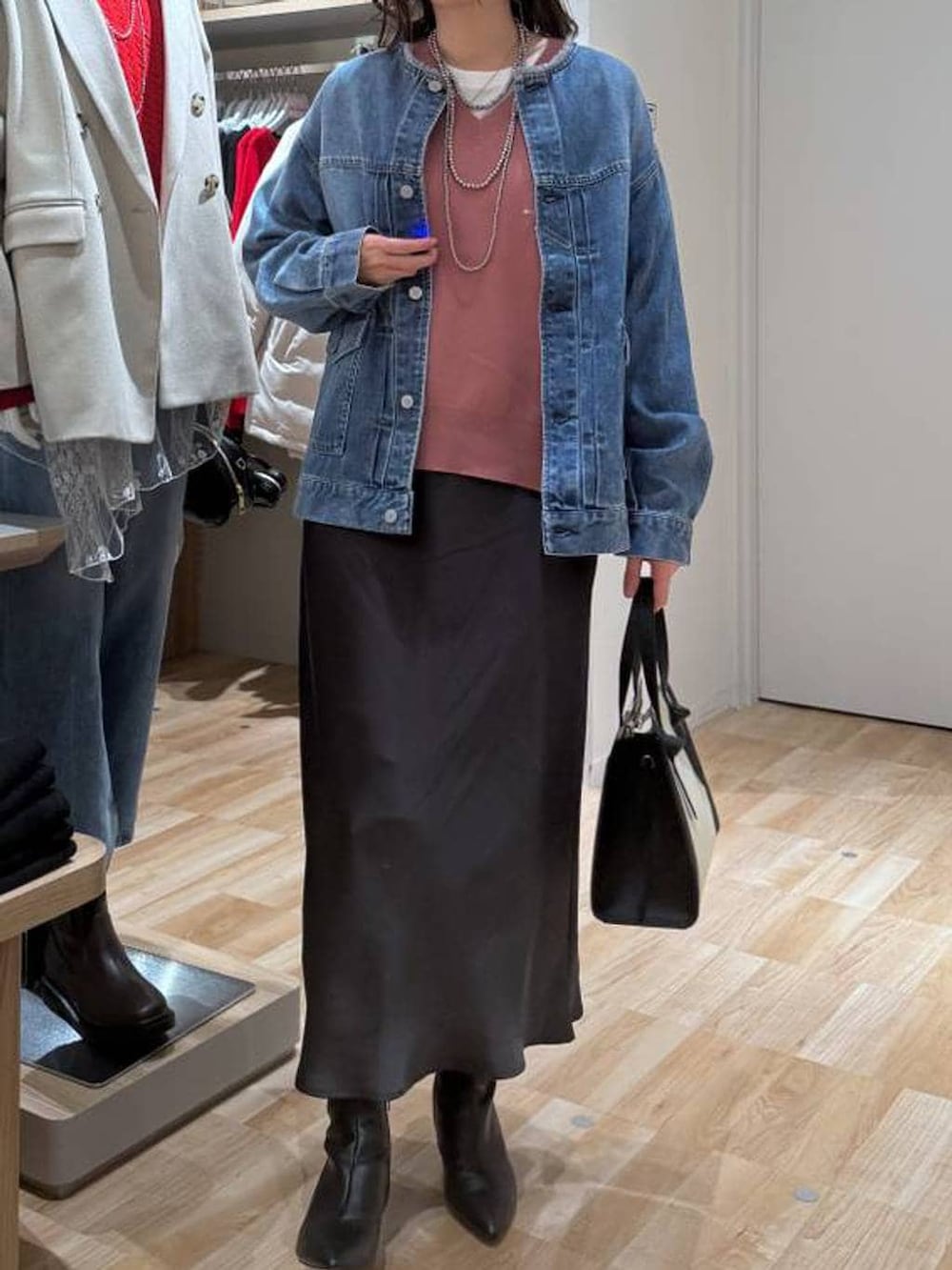 ホワイト系のショルダーバッグ、ピンク系のスウェット、ホワイト系のTシャツ/カットソーを着用したレディースの春コーディネートの6枚目の写真