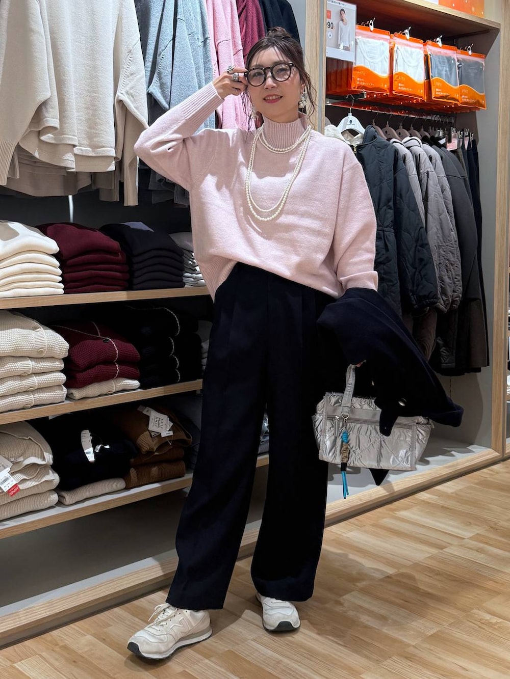 ブルー系のチェスターコート、シルバー系のボストンバッグ、ピンク系のニット/セーターを着用したレディースの冬コーディネートの6枚目の写真