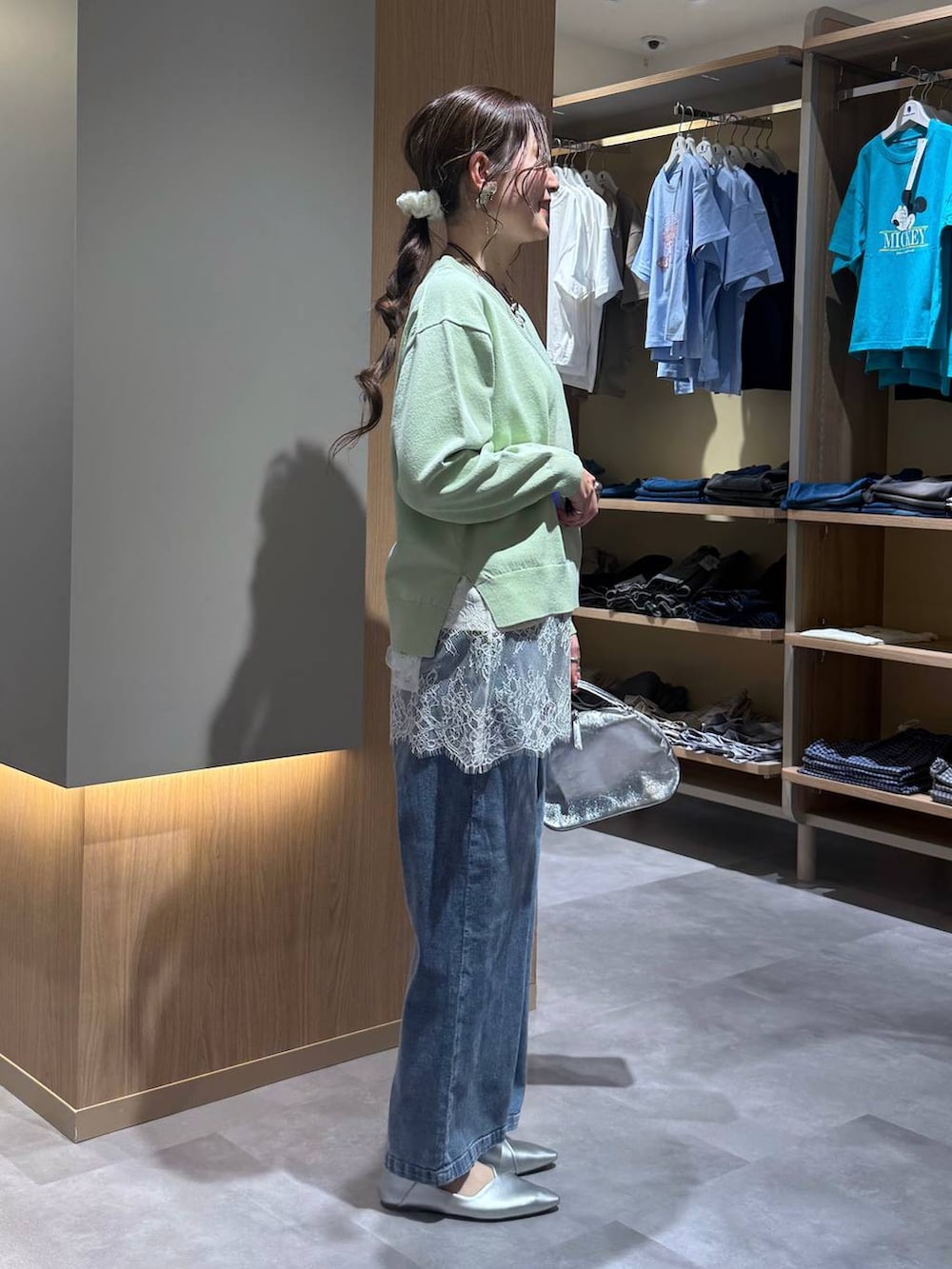 シルバー系のショルダーバッグ、シルバー系のパンプス、グリーン系のニット/セーターを着用したレディースの春コーディネートの3枚目の写真