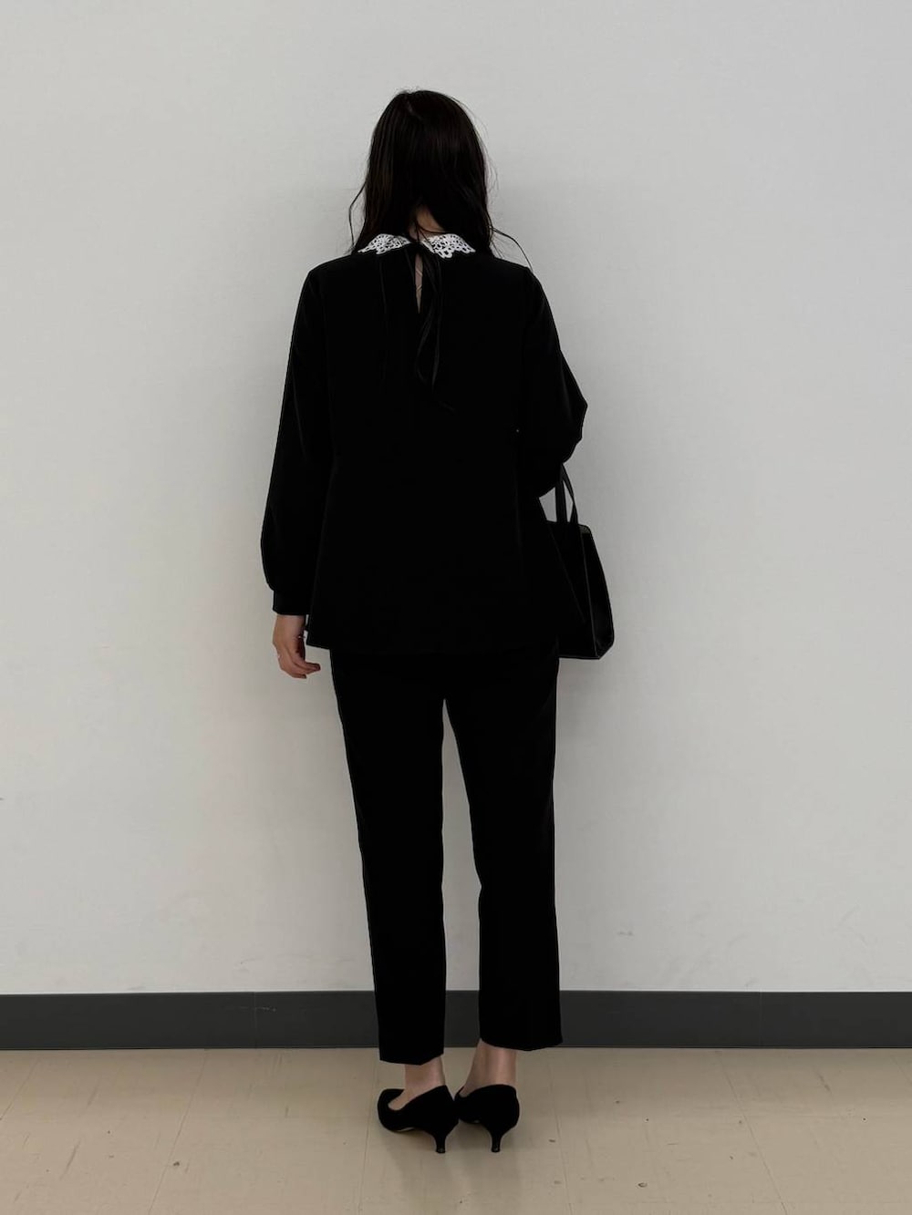 ブラック系のショルダーバッグ、ブラック系のセットアップ、ブラック系のパンプスを着用したレディースの冬コーディネートの5枚目の写真