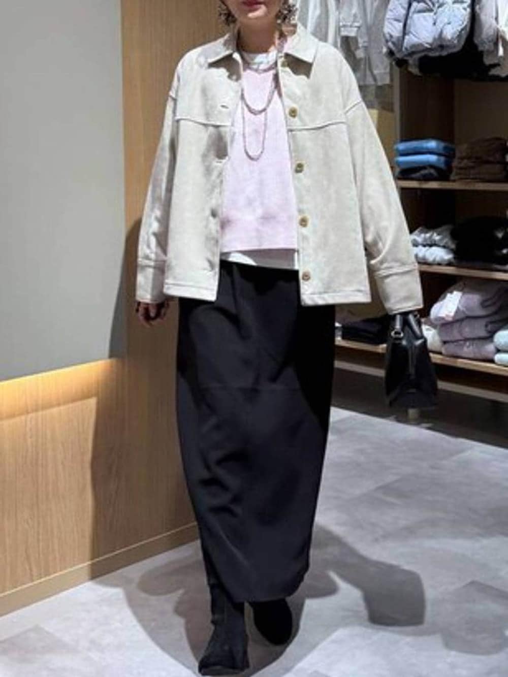 ブラック系のショルダーバッグ、ホワイト系のTシャツ/カットソー、ブラック系のブーツを着用したレディースの冬コーディネートの5枚目の写真