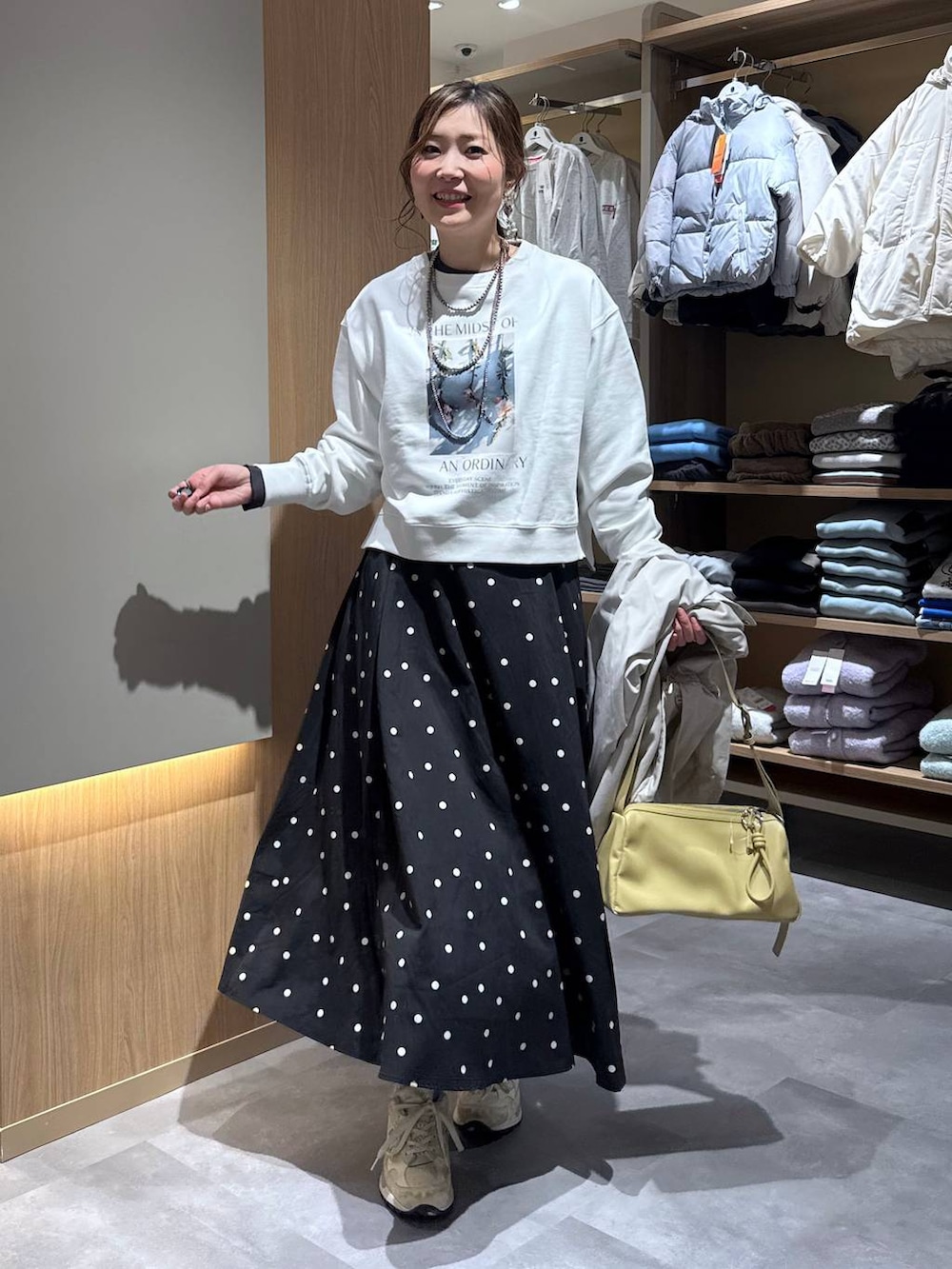 グレー系のニット/セーター、ホワイト系のスウェット、ベージュ系のマウンテンパーカーを着用したレディースの春コーディネートの6枚目の写真