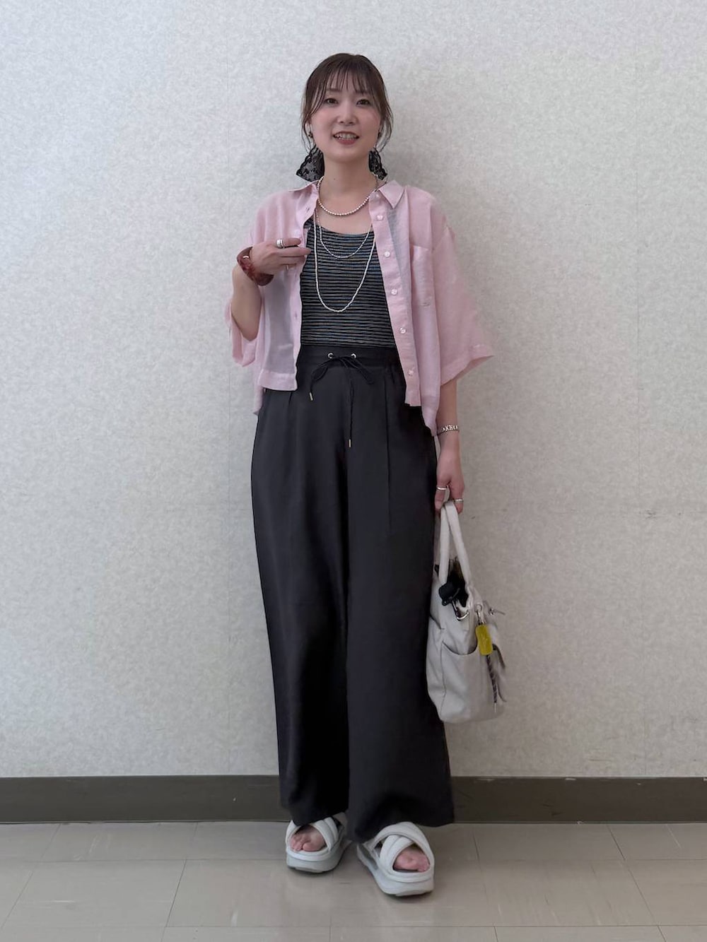 ブラック系のトートバッグ、ブラウン系のその他パンツ、ピンク系のシャツ/ブラウスを着用したレディースの夏コーディネートの2枚目の写真