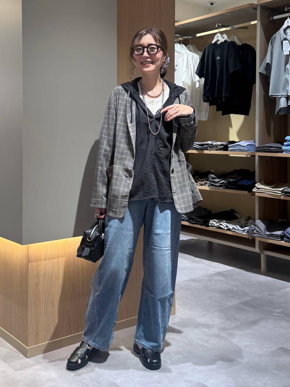 ブルー系のデニムパンツ、グレー系のテーラードジャケット、ホワイト系のタンクトップを着用したレディースの夏コーディネートの6枚目の写真