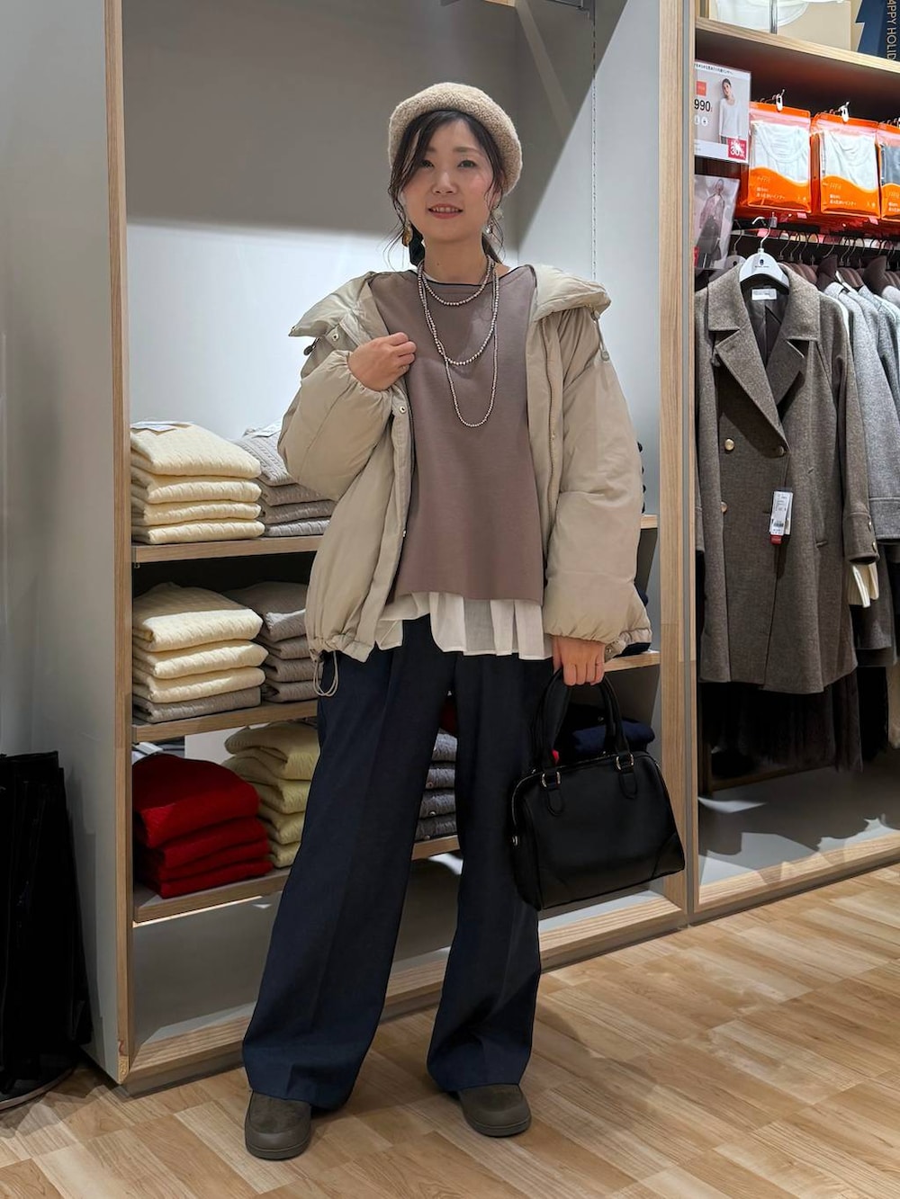 ベージュ系のダウンジャケット/コート、ブルー系のその他パンツ、ホワイト系のTシャツ/カットソーを着用したレディースの春コーディネートの6枚目の写真