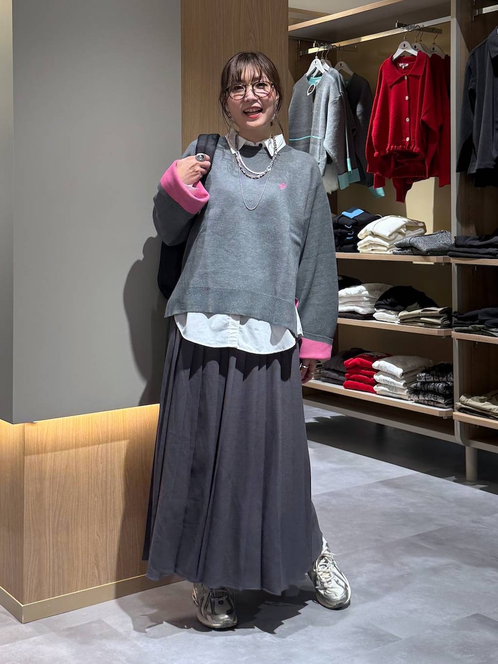 ホワイト系のシャツ/ブラウス、ブラック系のバックパック/リュック、グレー系のニット/セーターを着用したレディースの秋コーディネートの2枚目の写真