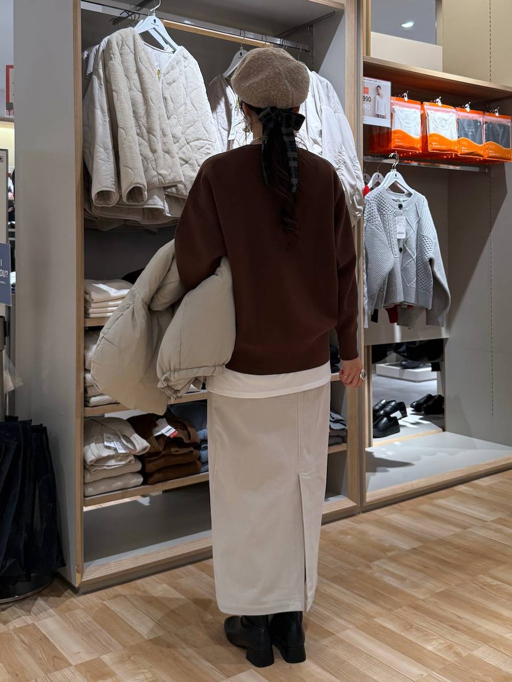 ベージュ系のダウンジャケット/コート、ブラウン系のスウェット、グレー系のスカートを着用したレディースの冬コーディネートの8枚目の写真