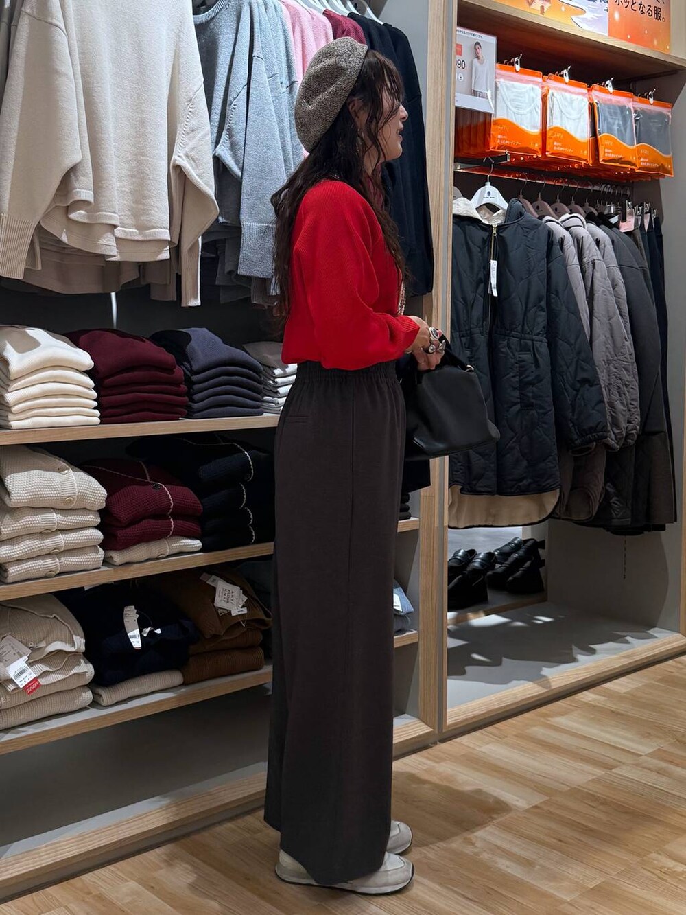 ブラック系のショルダーバッグ、レッド系のニット/セーター、ブルー系のテーラードジャケットを着用したレディースの冬コーディネートの7枚目の写真