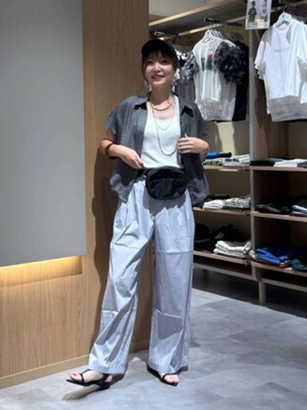 グレー系のその他パンツ、ホワイト系のタンクトップ、ブラック系のボディバッグ/ウエストポーチを着用したレディースの夏コーディネートの2枚目の写真