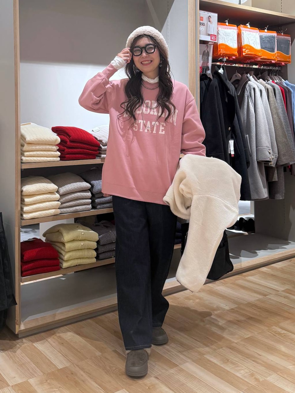 ブラック系のトートバッグ、ホワイト系のブルゾン、ブルー系のデニムパンツを着用したレディースの冬コーディネートの6枚目の写真