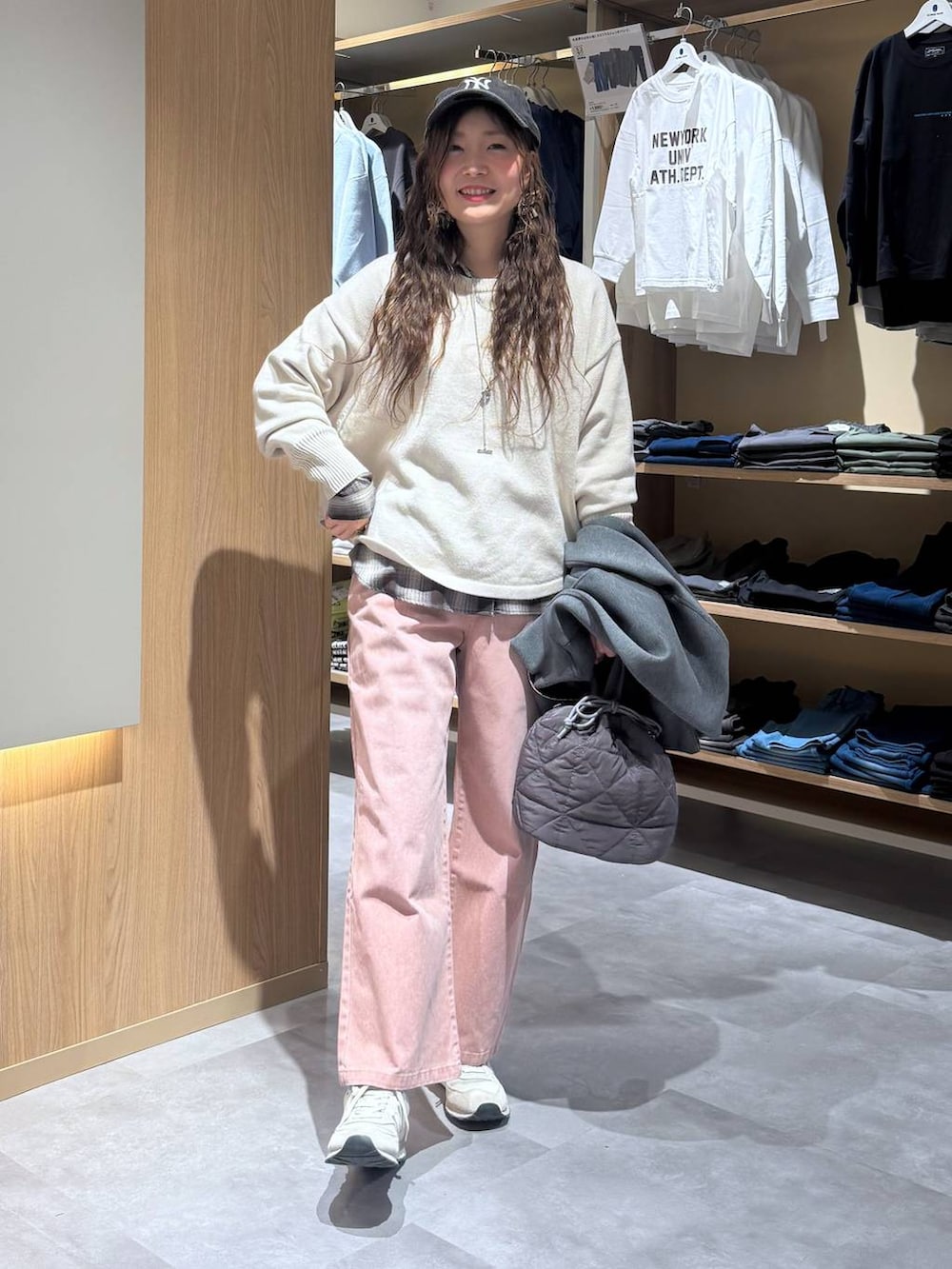 ベージュ系のニット/セーター、グレー系のハンドバッグ、ピンク系のデニムパンツを着用したレディースの春コーディネートの2枚目の写真