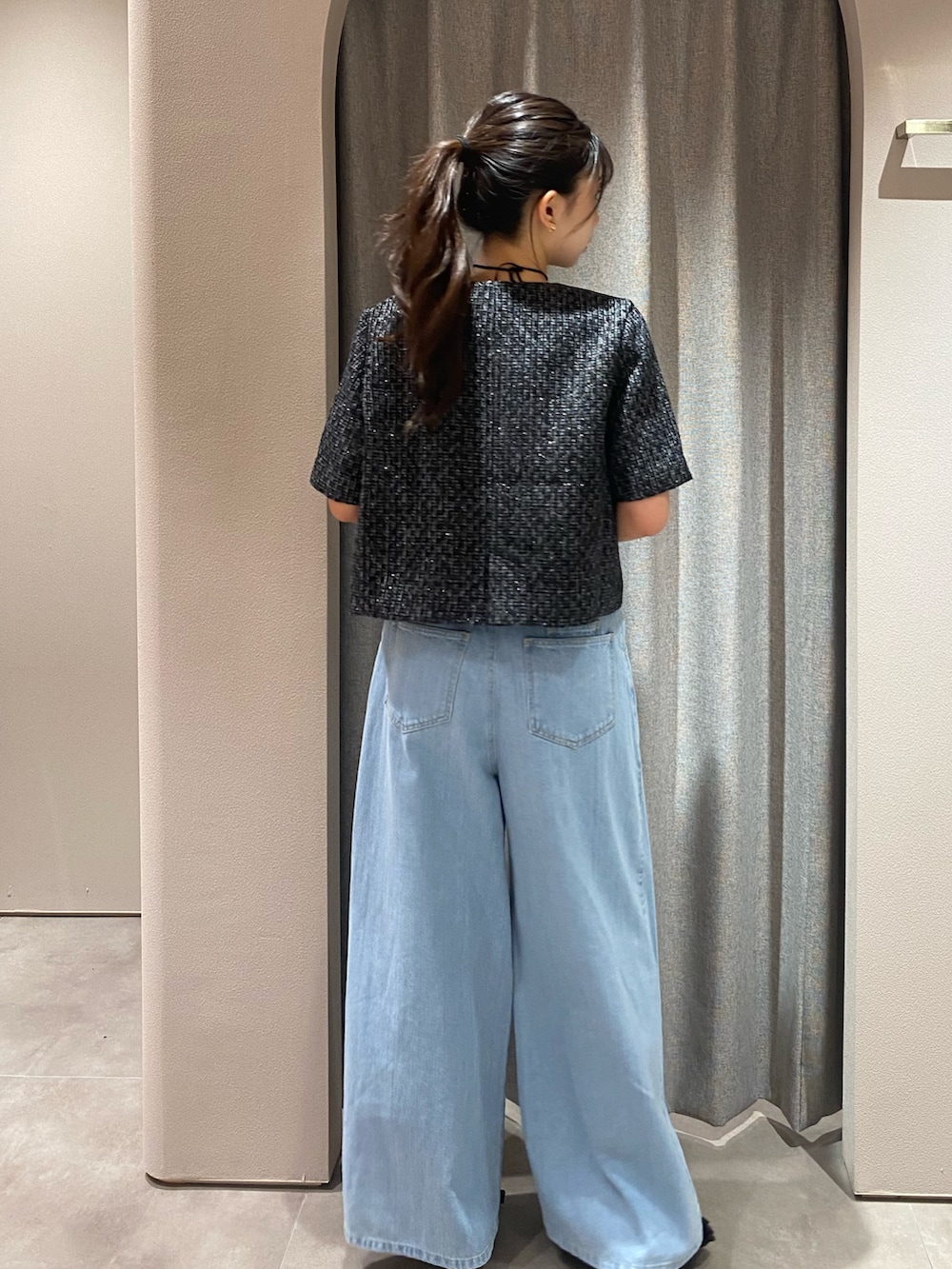 ブラック系のノーカラージャケット、ブルー系のデニムパンツ、ブラック系のパンプスを着用したレディースの夏コーディネートの4枚目の写真