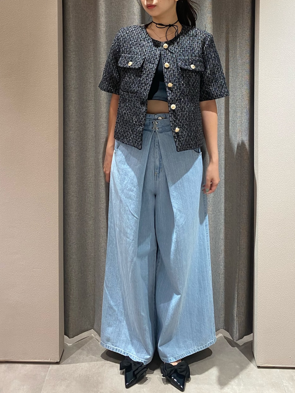ブラック系のノーカラージャケット、ブルー系のデニムパンツ、ブラック系のパンプスを着用したレディースの夏コーディネートの2枚目の写真