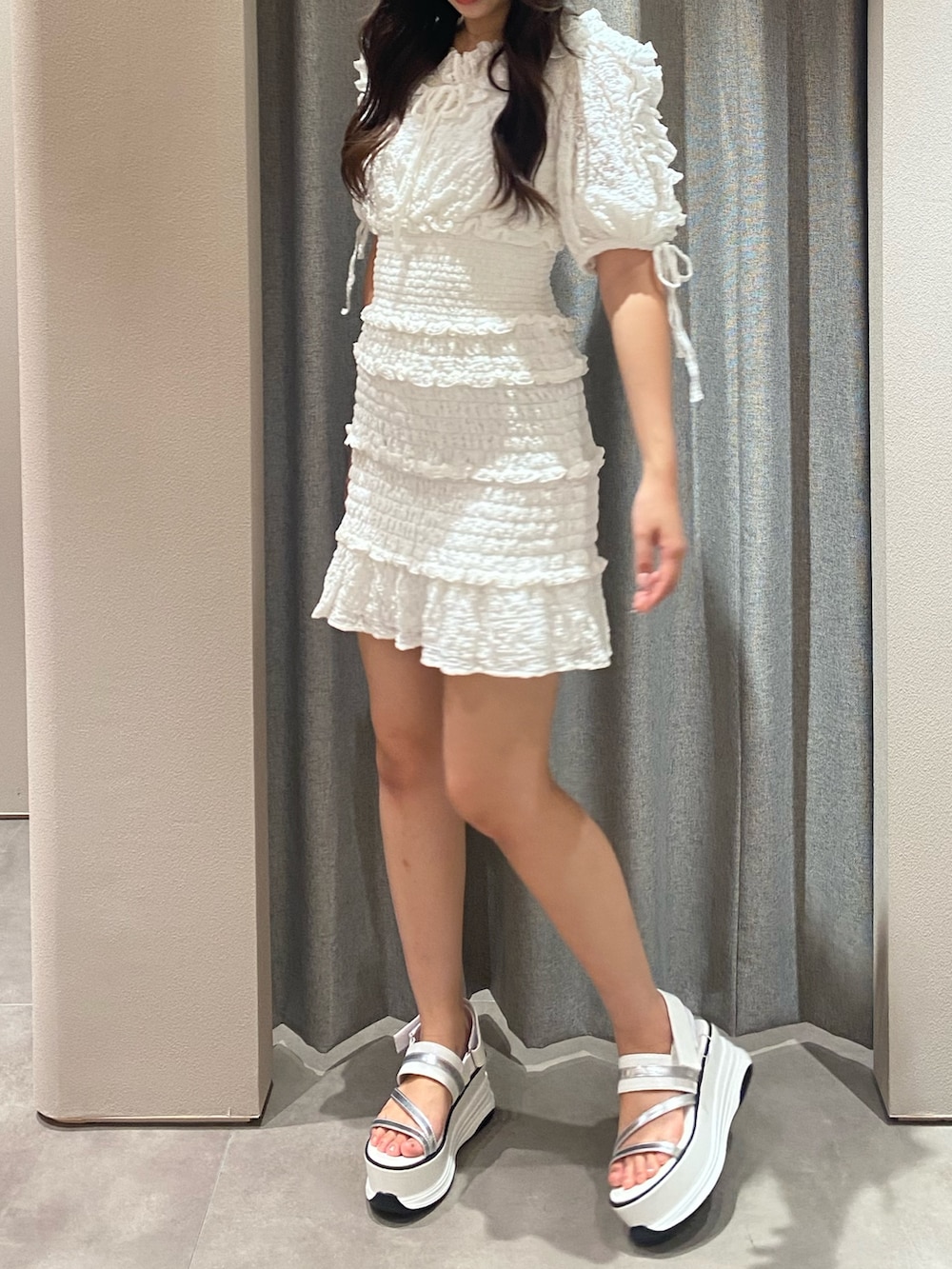 ホワイト系のワンピース、ホワイト系のサンダルを着用したレディースの秋コーディネートの8枚目の写真