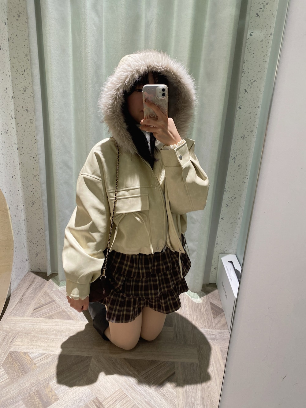 ブラウン系のショルダーバッグ、ホワイト系のニット/セーター、ホワイト系のブルゾンを着用したレディースの秋コーディネートの4枚目の写真