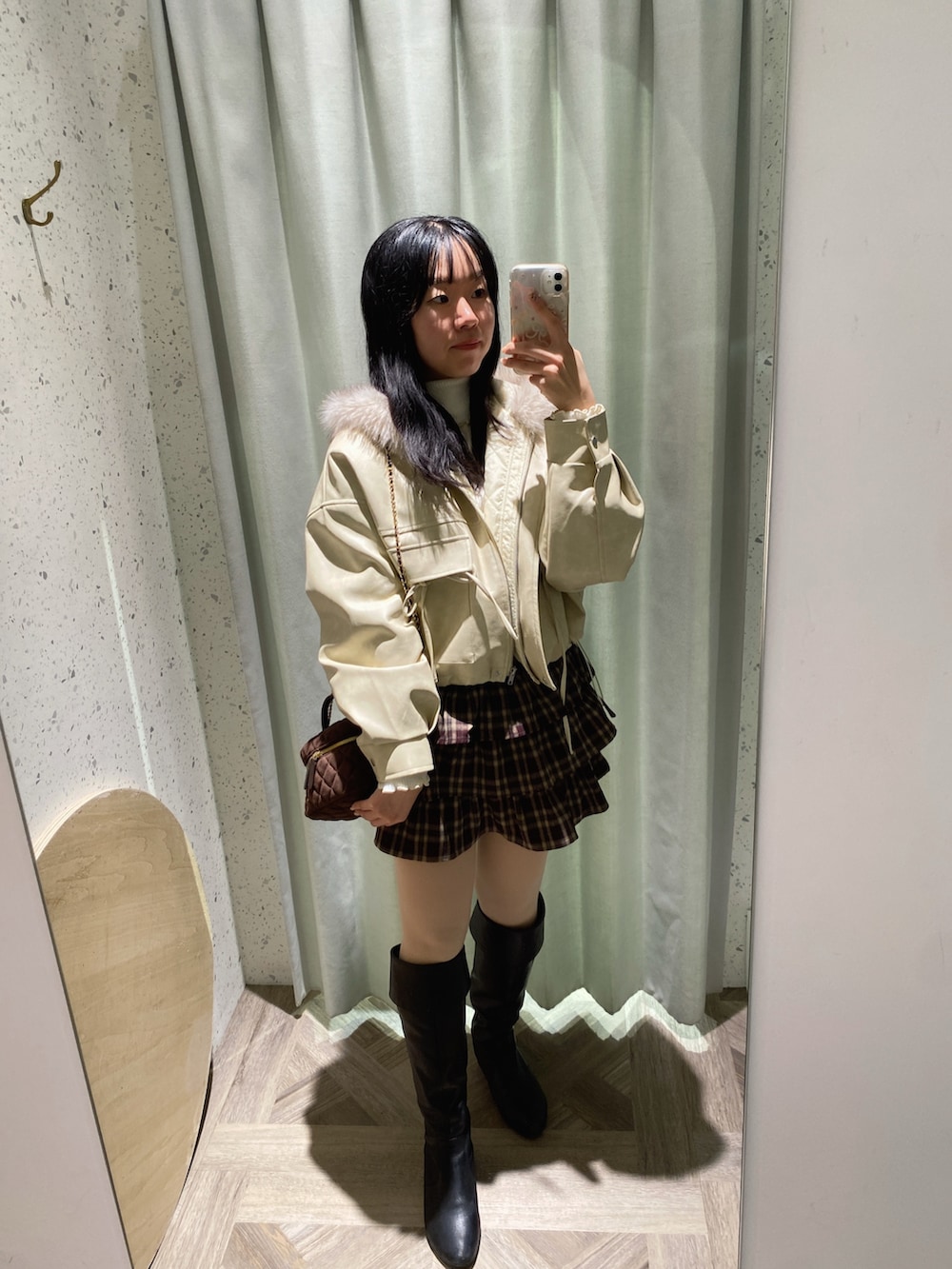 ブラウン系のショルダーバッグ、ホワイト系のニット/セーター、ホワイト系のブルゾンを着用したレディースの秋コーディネートの5枚目の写真