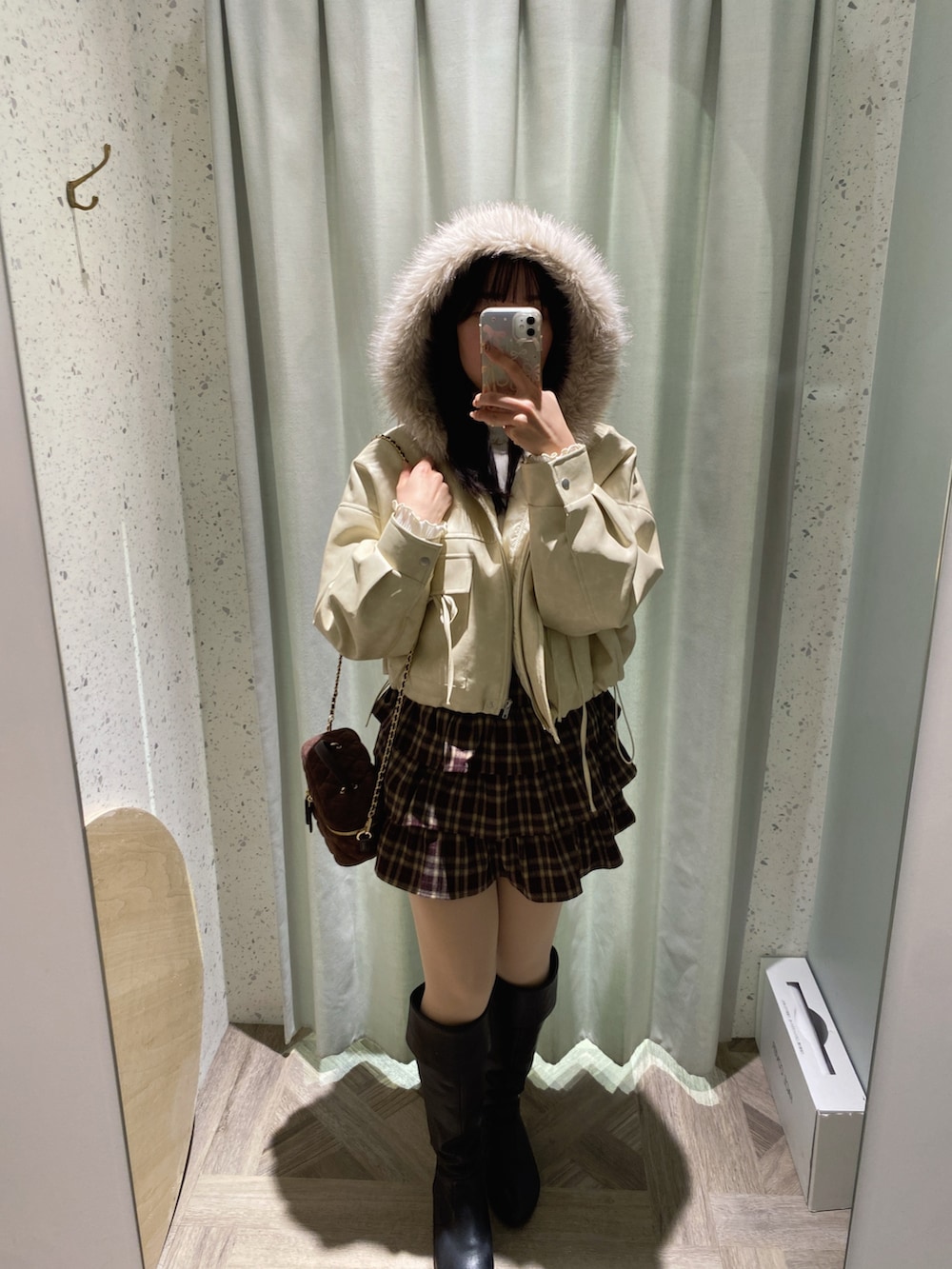 ブラウン系のショルダーバッグ、ホワイト系のニット/セーター、ホワイト系のブルゾンを着用したレディースの秋コーディネートの2枚目の写真