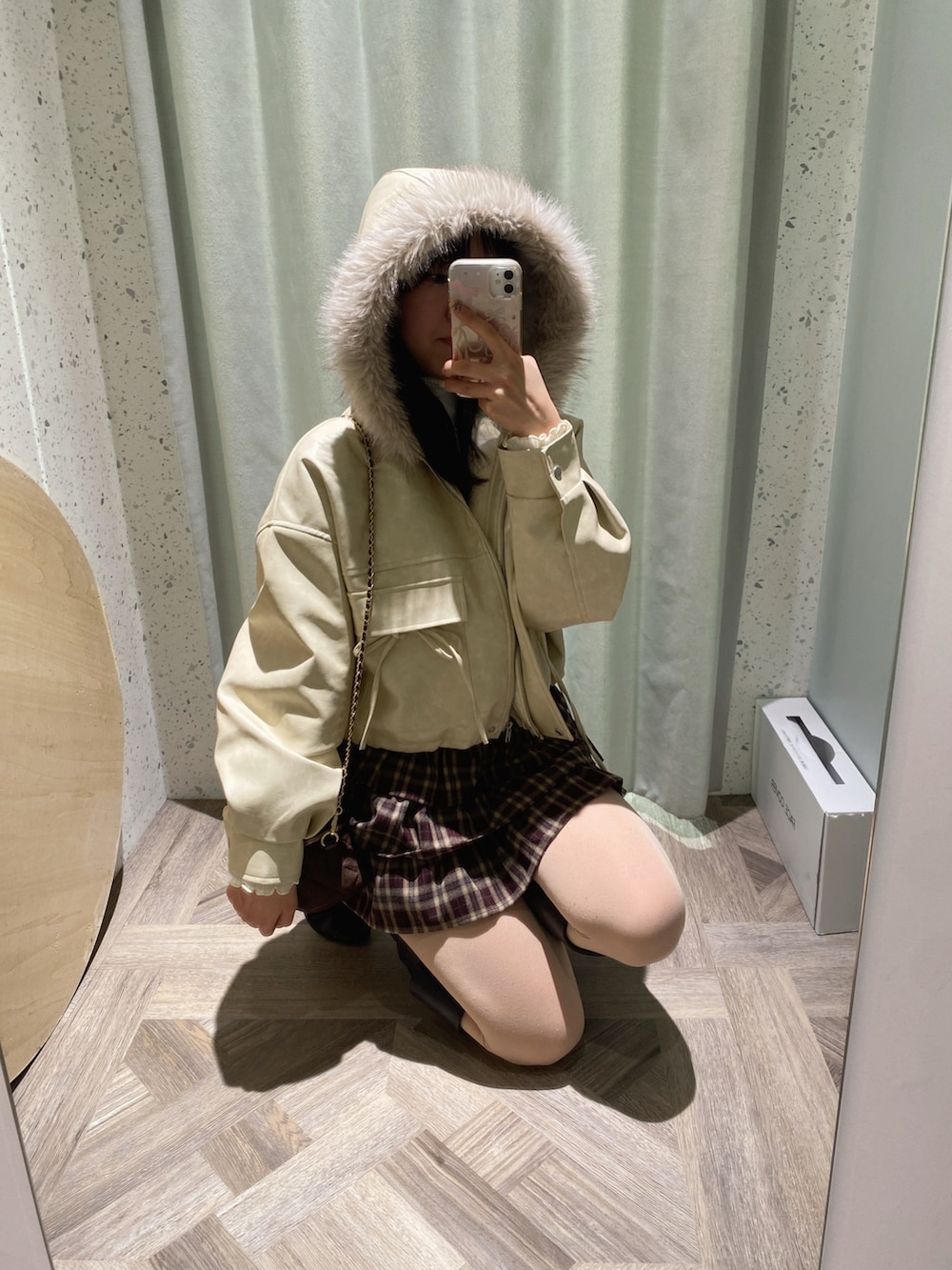 ブラウン系のショルダーバッグ、ホワイト系のニット/セーター、ホワイト系のブルゾンを着用したレディースの秋コーディネートの3枚目の写真