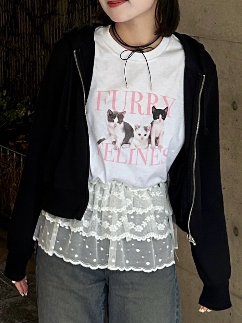 ブルー系のデニムパンツ、ホワイト系のTシャツ/カットソー、ブラック系のパーカーを着用したレディースの春コーディネートの3枚目の写真