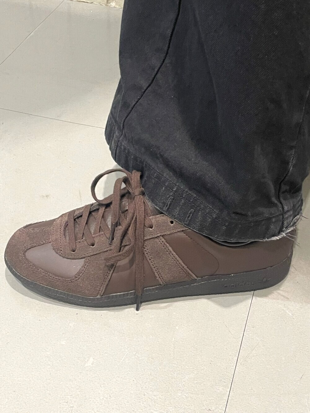 ホワイト系のトップス、ブラウン系のスニーカーを着用したメンズの夏コーディネートの4枚目の写真