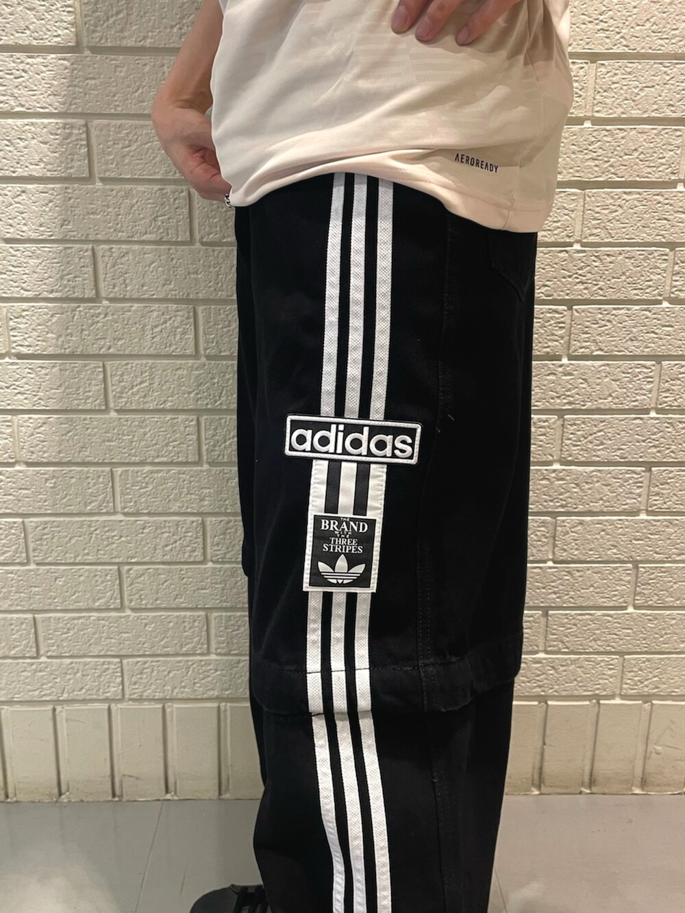 ブラック系のスニーカー、ブラック系のデニムパンツ、ベージュ系のTシャツ/カットソーを着用したメンズの春コーディネートの3枚目の写真