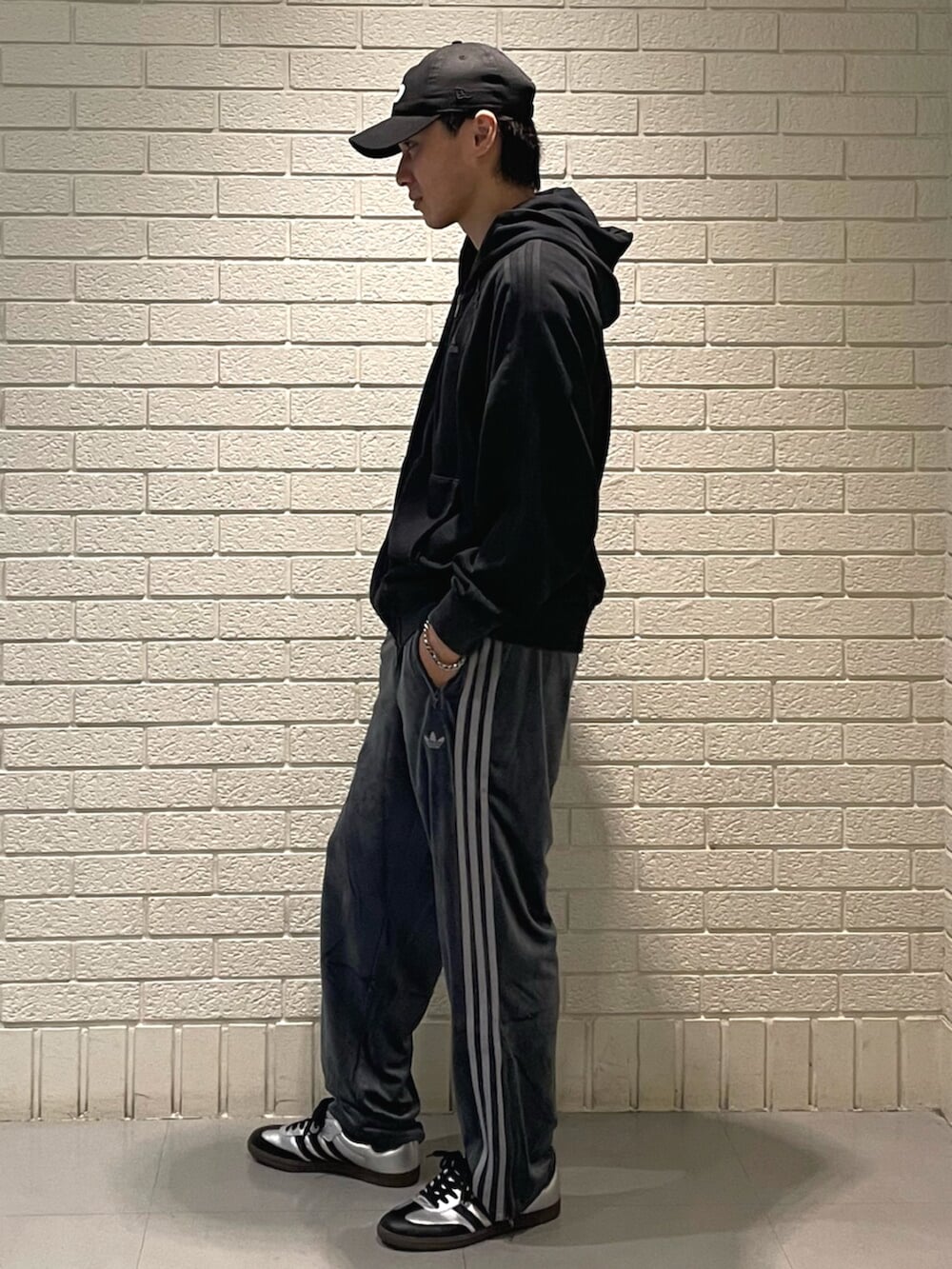 ブラック系のパーカー、グレー系のその他パンツ、シルバー系のスニーカーを着用したメンズの秋コーディネートの2枚目の写真