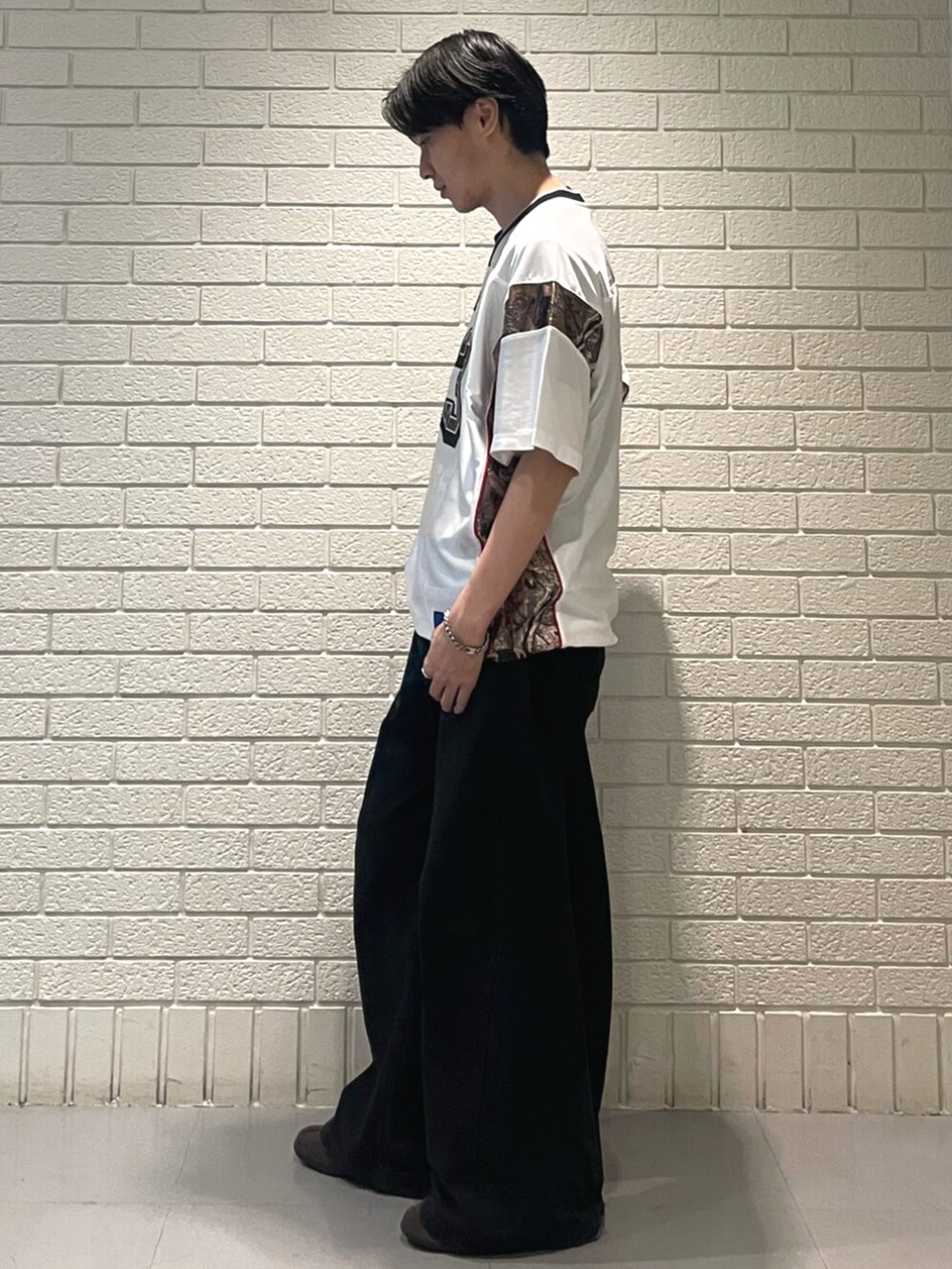 ホワイト系のトップス、ブラウン系のスニーカーを着用したメンズの夏コーディネートの2枚目の写真