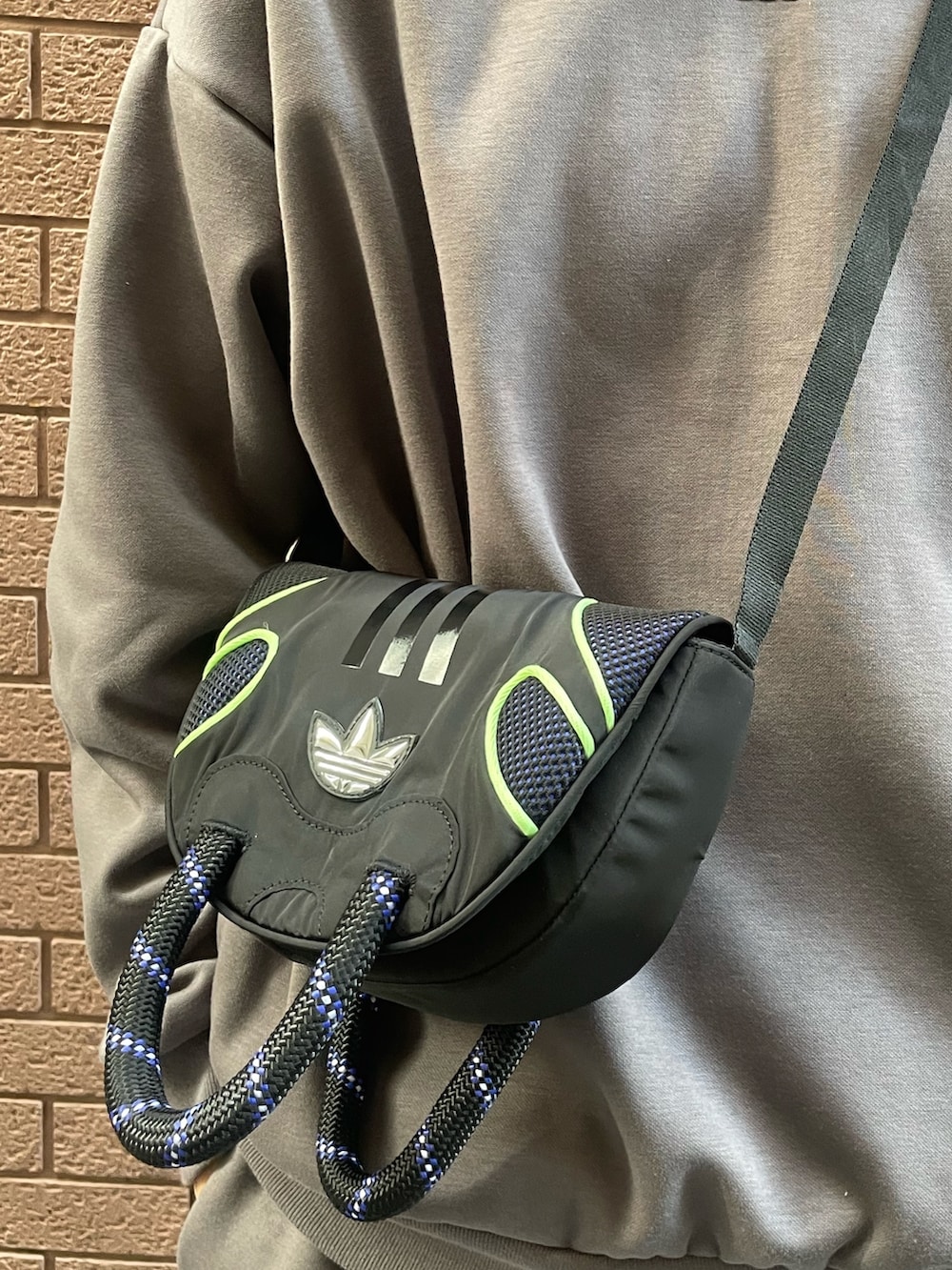 グレー系のパンツ、グレー系のトップス、ブラック系のショルダーバッグを着用したメンズの冬コーディネートの4枚目の写真