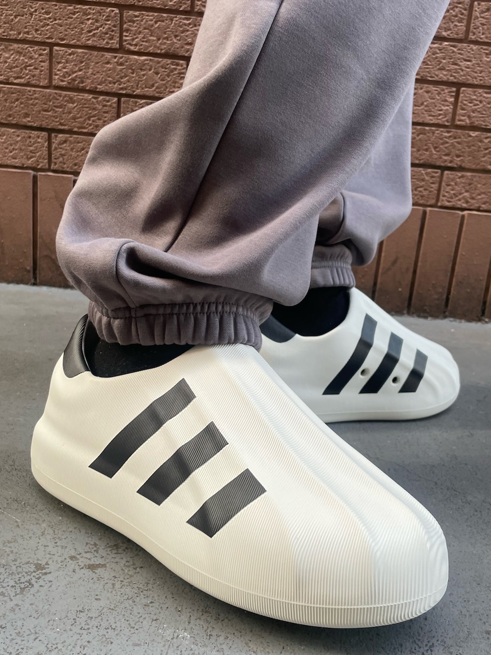 グレー系のパンツ、グレー系のトップス、ブラック系のショルダーバッグを着用したメンズの冬コーディネートの6枚目の写真