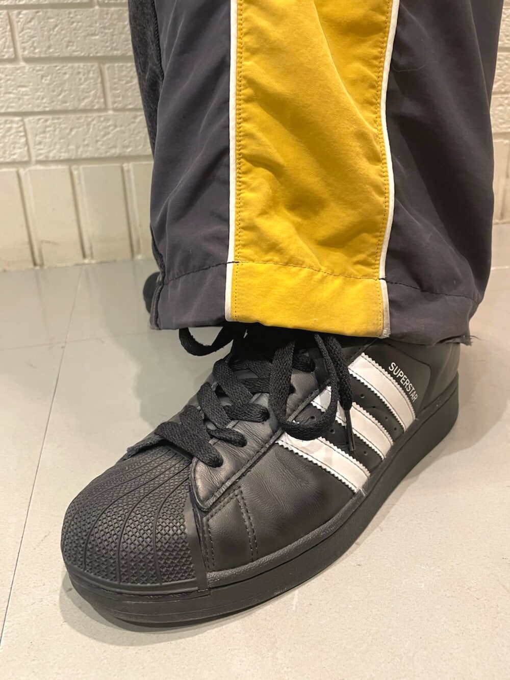 ブラック系のスニーカー、ブラック系のTシャツ/カットソーを着用したメンズの夏コーディネートの2枚目の写真