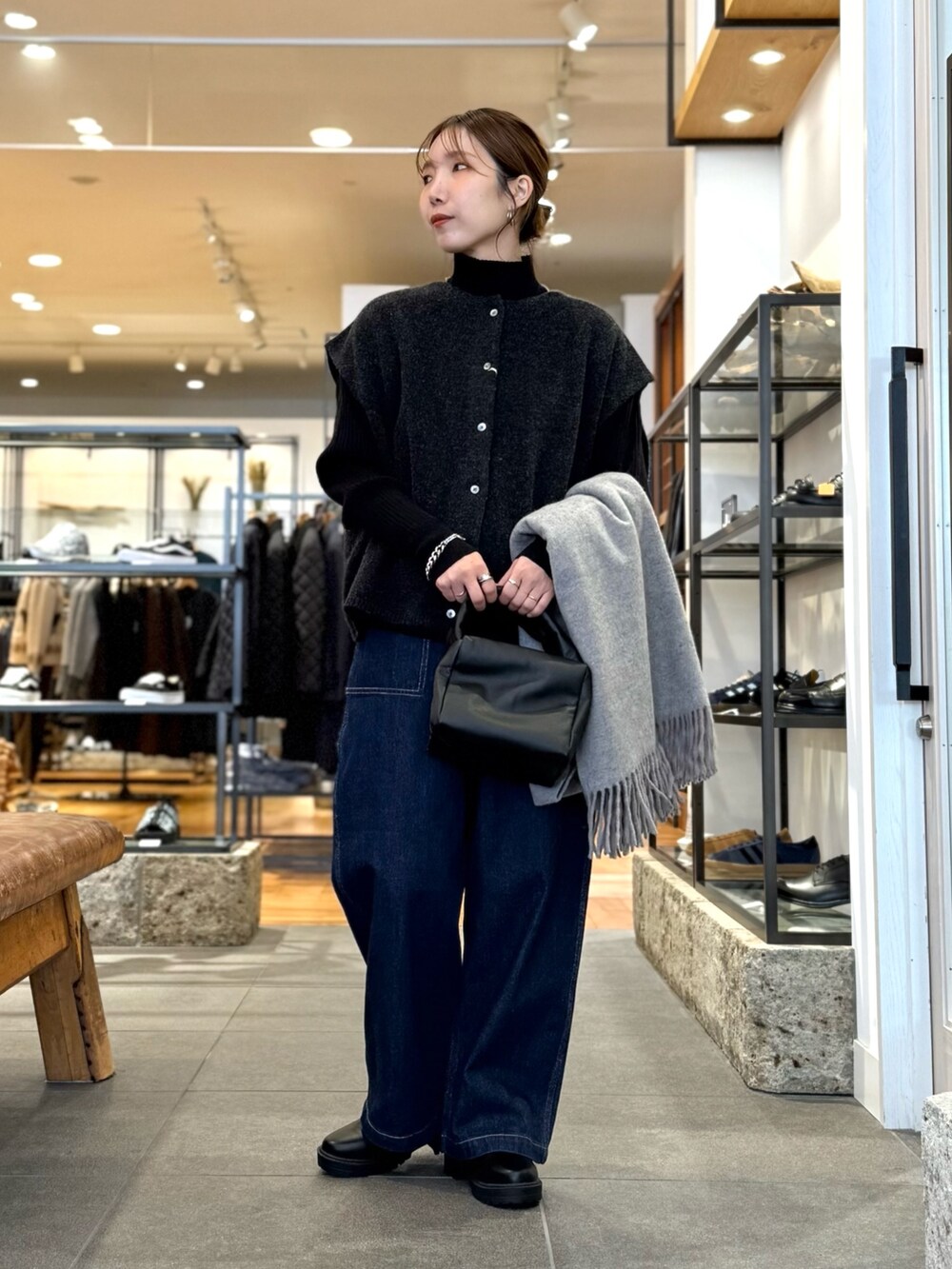 グレー系のニット/セーター、ブルー系のデニムパンツ、ブラック系のニット/セーターを着用したレディースの冬コーディネートの3枚目の写真