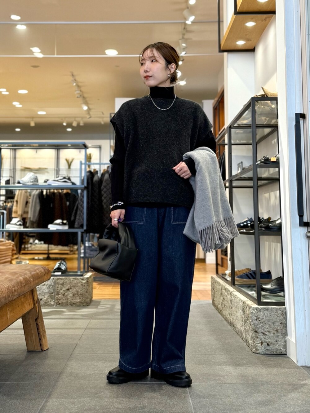 グレー系のニット/セーター、ブルー系のデニムパンツ、ブラック系のニット/セーターを着用したレディースの冬コーディネートの6枚目の写真