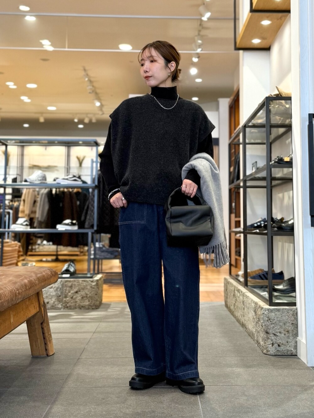 グレー系のニット/セーター、ブルー系のデニムパンツ、ブラック系のニット/セーターを着用したレディースの冬コーディネートの2枚目の写真